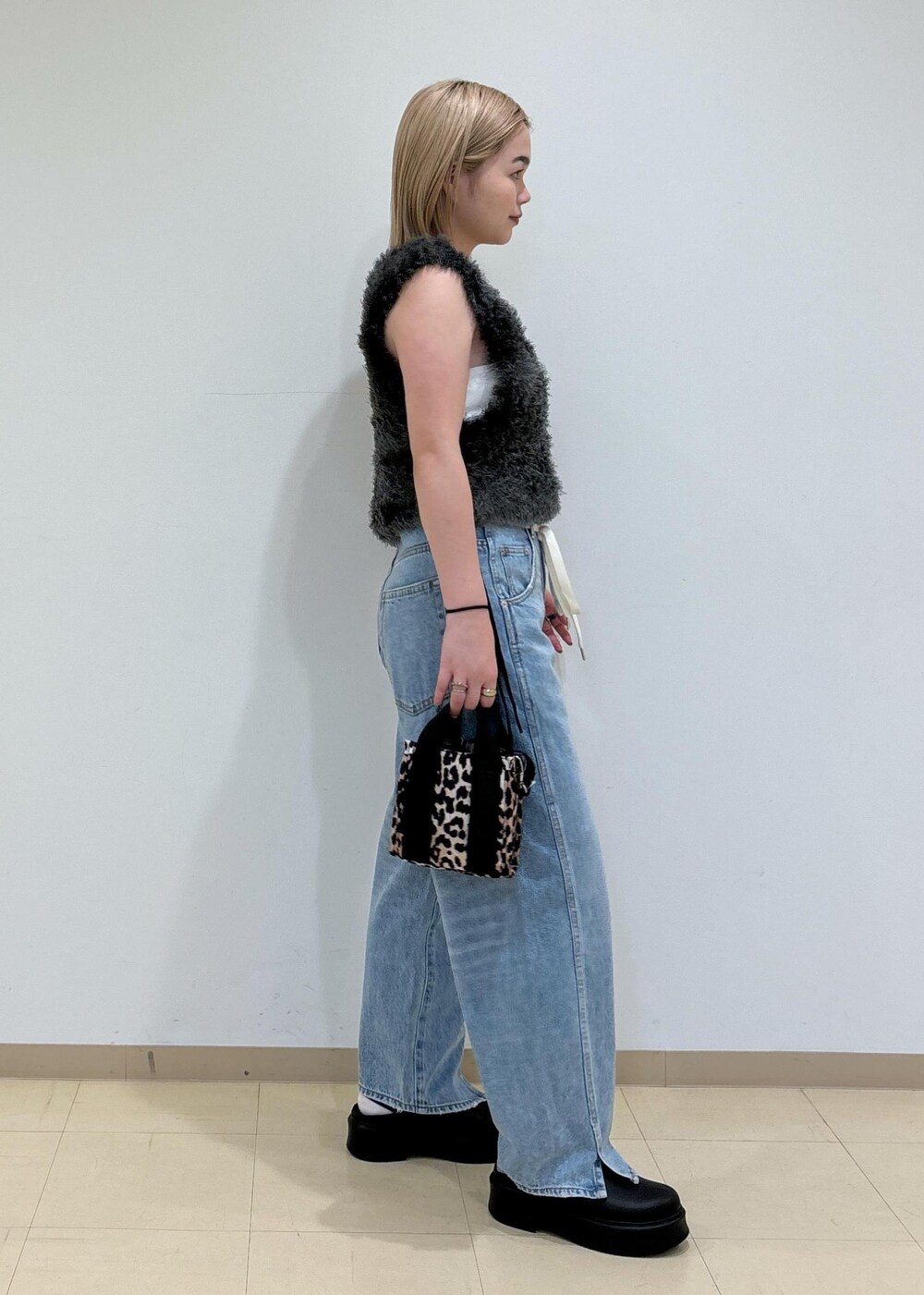 ホワイト系のキャミソール、ブラック系のサンダル、グレー系のベストを着用したレディースの夏コーディネートの4枚目の写真