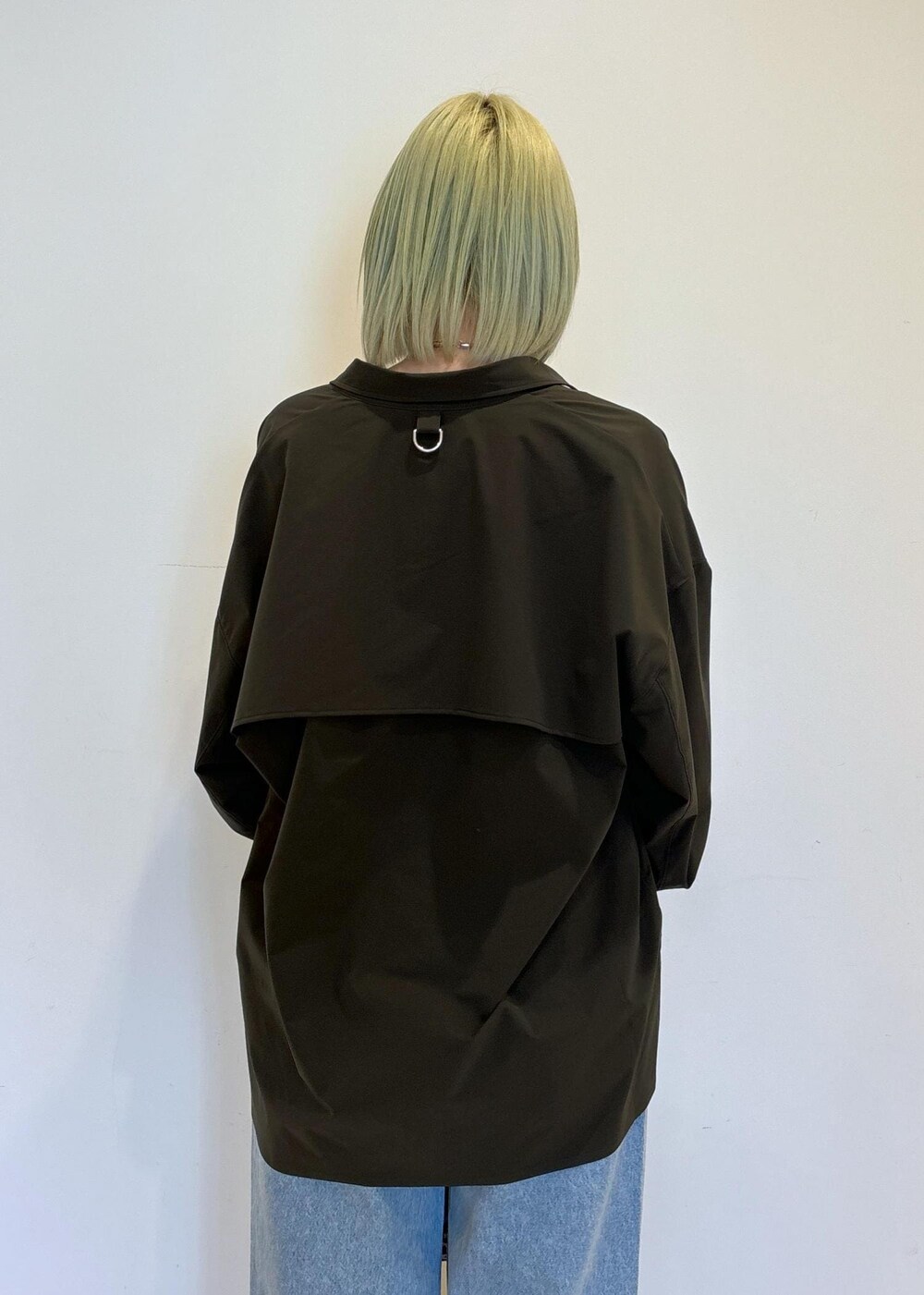 ホワイト系のタンクトップ、ブラウン系のショルダーバッグ、ブルー系のデニムパンツを着用したレディースの春コーディネートの7枚目の写真