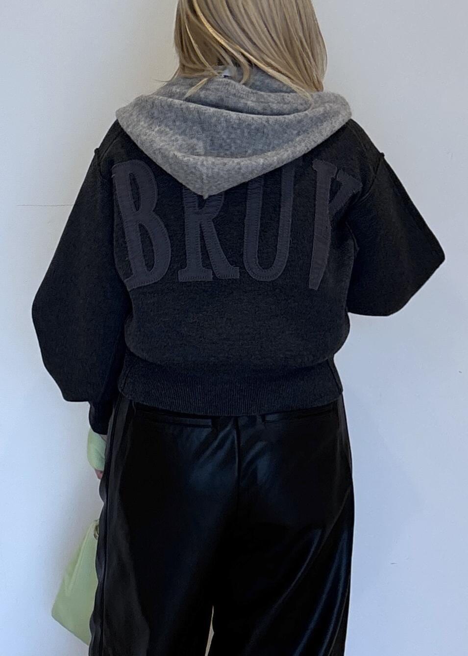 グリーン系のハンドバッグ、ブラック系のパンプス、グレー系のニット/セーターを着用したレディースの秋コーディネートの7枚目の写真