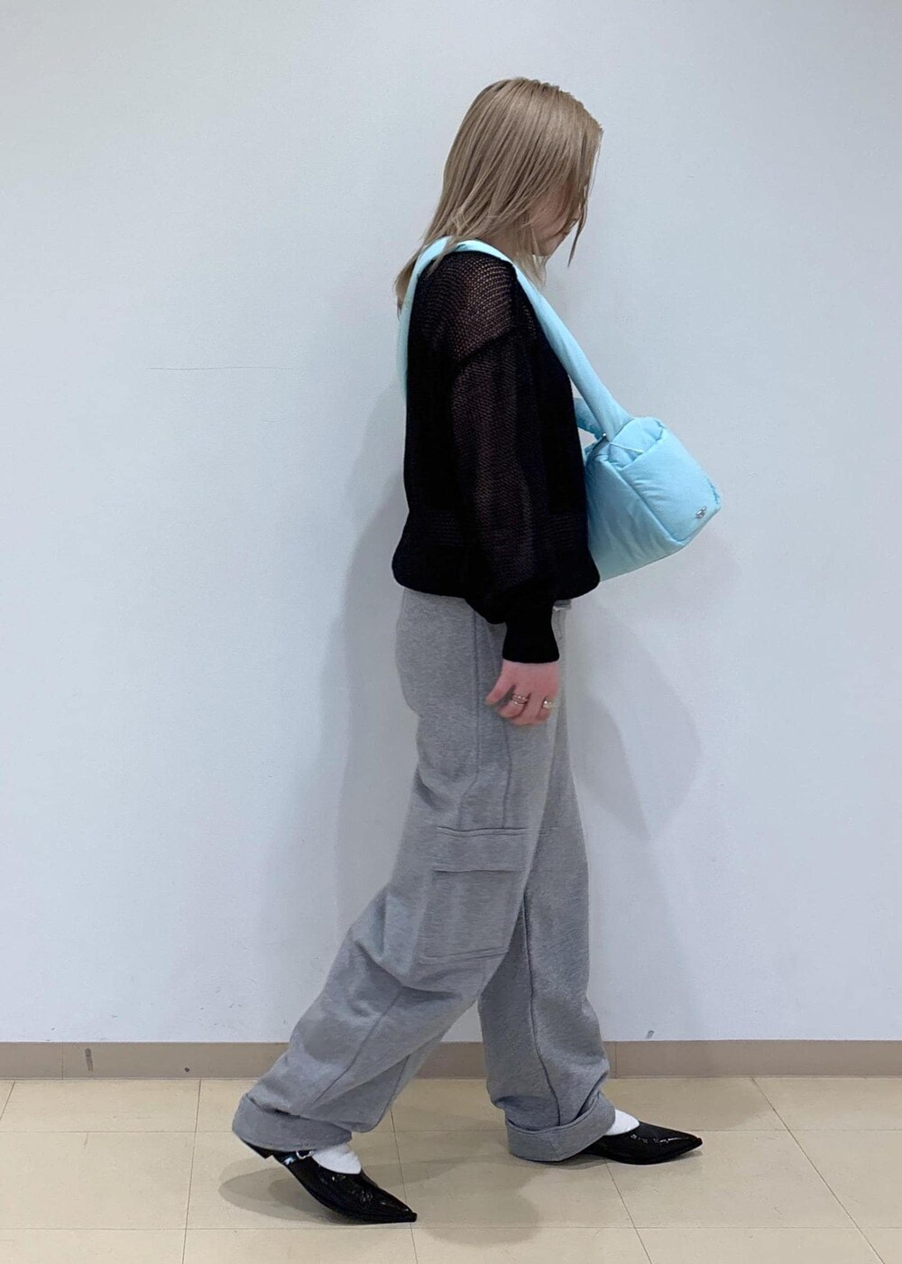 ブラック系のその他シューズ、ブルー系のショルダーバッグ、ブラック系のニット/セーターを着用したレディースの春コーディネートの4枚目の写真