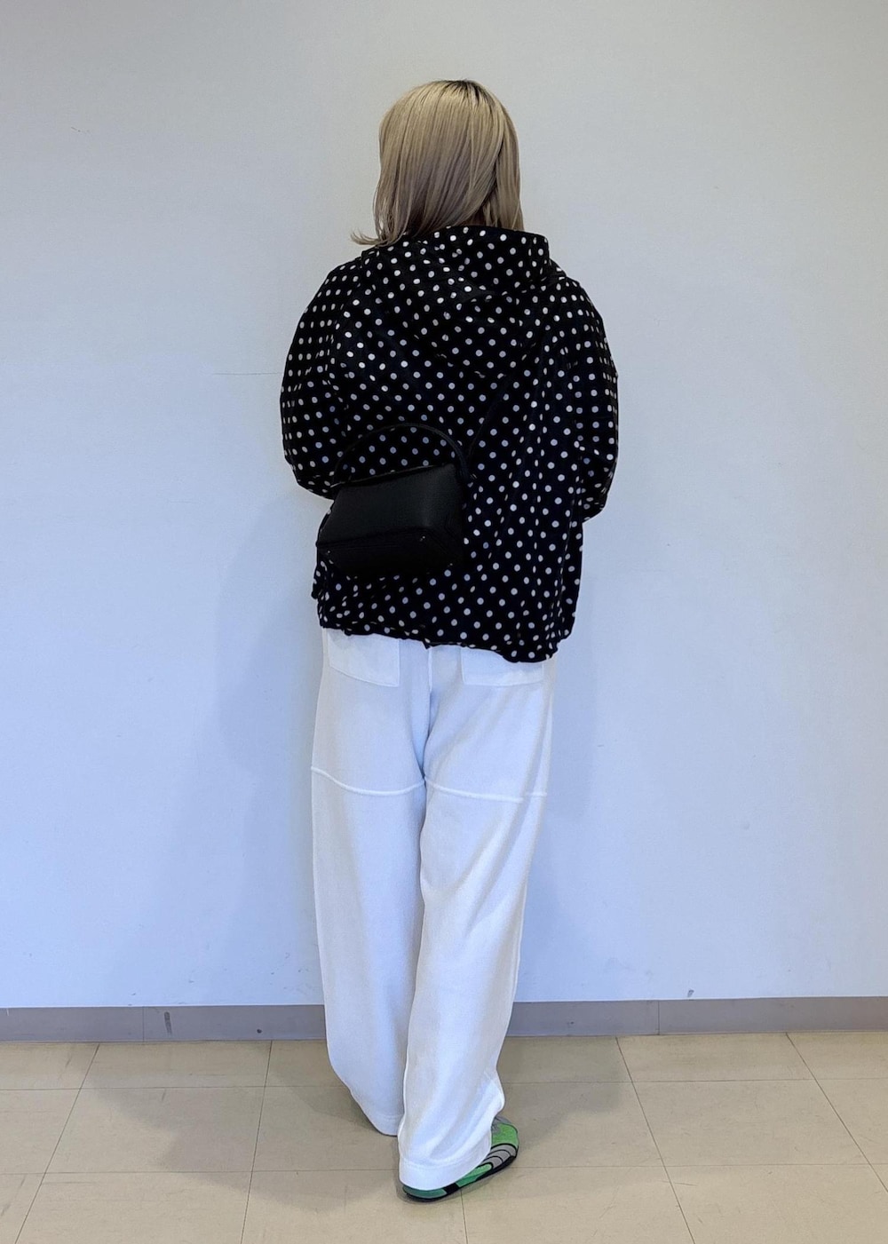 ホワイト系のその他パンツ、ブラック系のナイロンジャケットを着用したレディースの春コーディネートの3枚目の写真