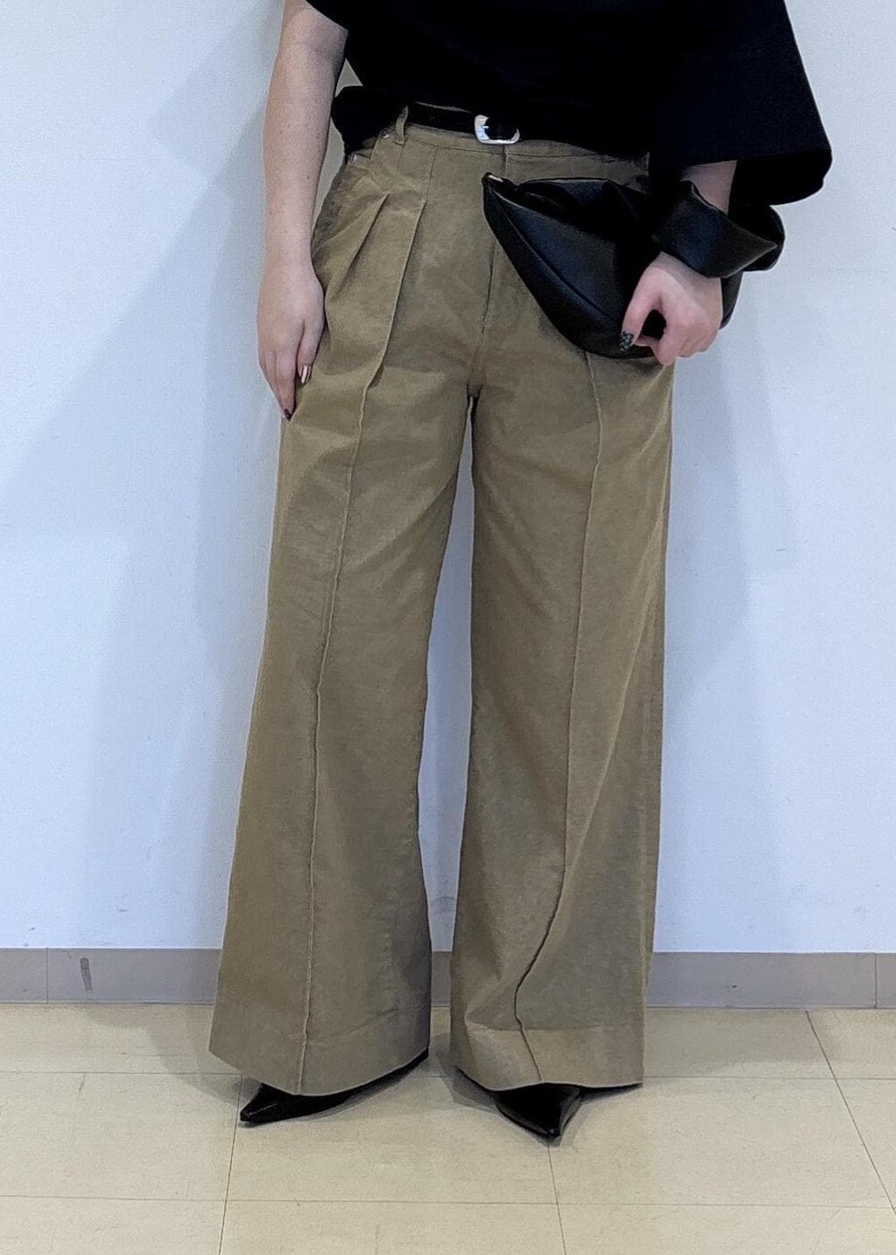 ブラック系のパンプス、ブラック系のショルダーバッグ、ベージュ系のデニムパンツを着用したレディースの春コーディネートの5枚目の写真