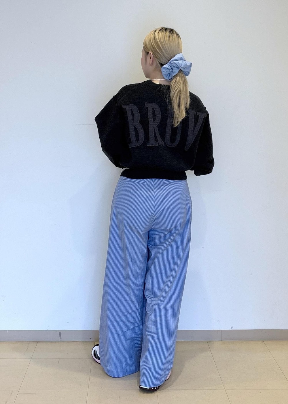 ブルー系のスラックス、グレー系のニット/セーターを着用したレディースの秋コーディネートの3枚目の写真