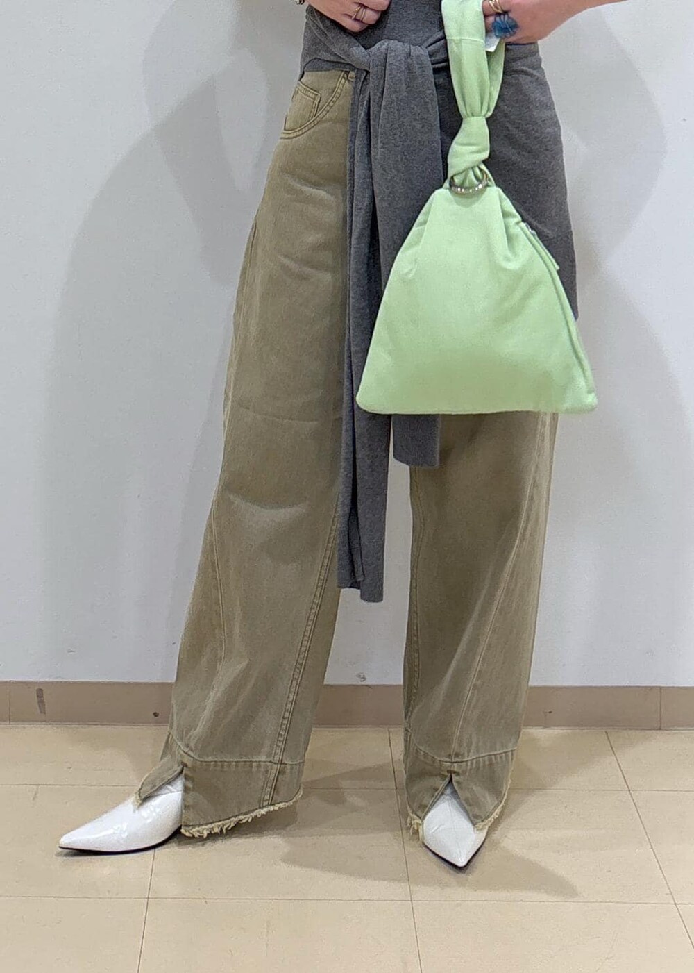 ホワイト系のパンプス、グレー系のニット/セーター、ベージュ系のデニムパンツを着用したレディースの夏コーディネートの6枚目の写真