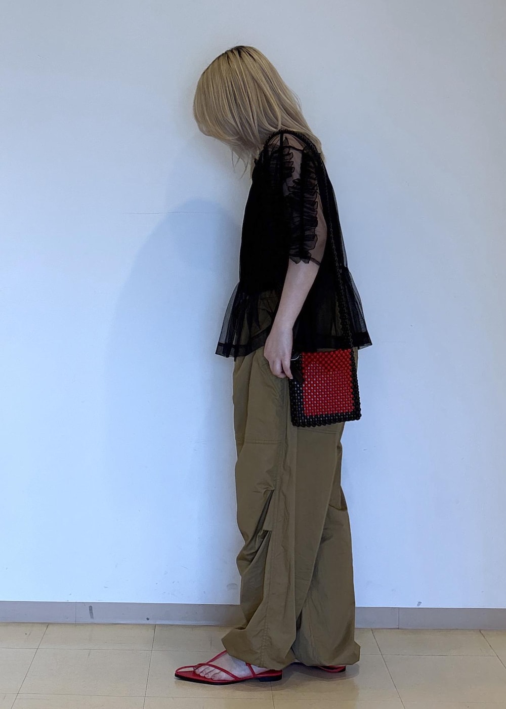 レッド系のサンダル、ブラック系のTシャツ/カットソー、レッド系のショルダーバッグを着用したレディースの春コーディネートの2枚目の写真