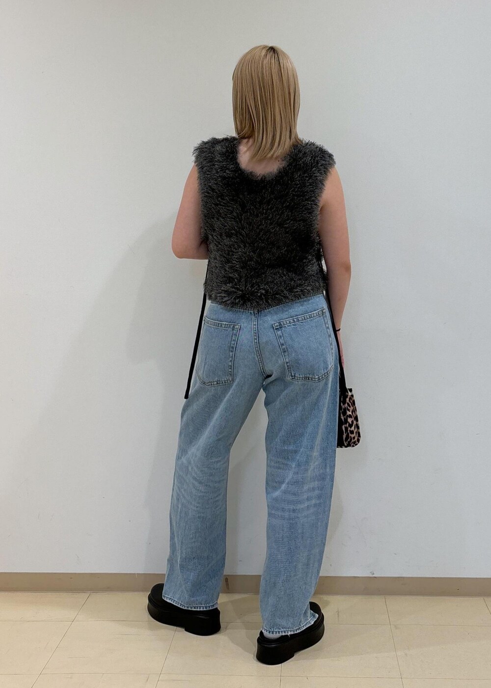 ホワイト系のキャミソール、ブラック系のサンダル、グレー系のベストを着用したレディースの夏コーディネートの3枚目の写真