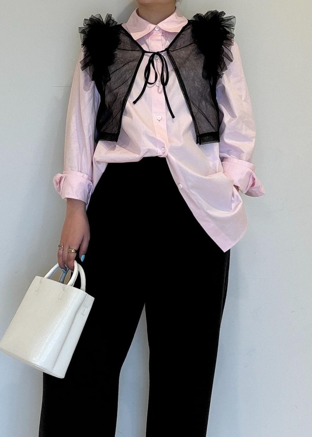 ホワイト系のハンドバッグ、ホワイト系のパンプス、ブラック系のTシャツ/カットソーを着用したレディースの夏コーディネートの5枚目の写真