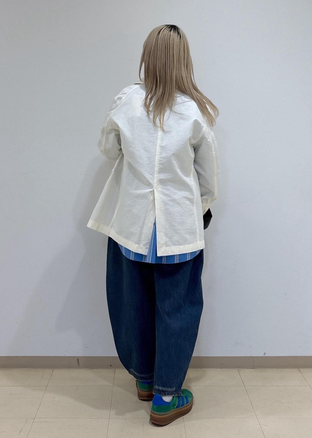 ブルー系のシャツ/ブラウス、ホワイト系のテーラードジャケット、ブルー系のデニムパンツを着用したレディースの春コーディネートの3枚目の写真