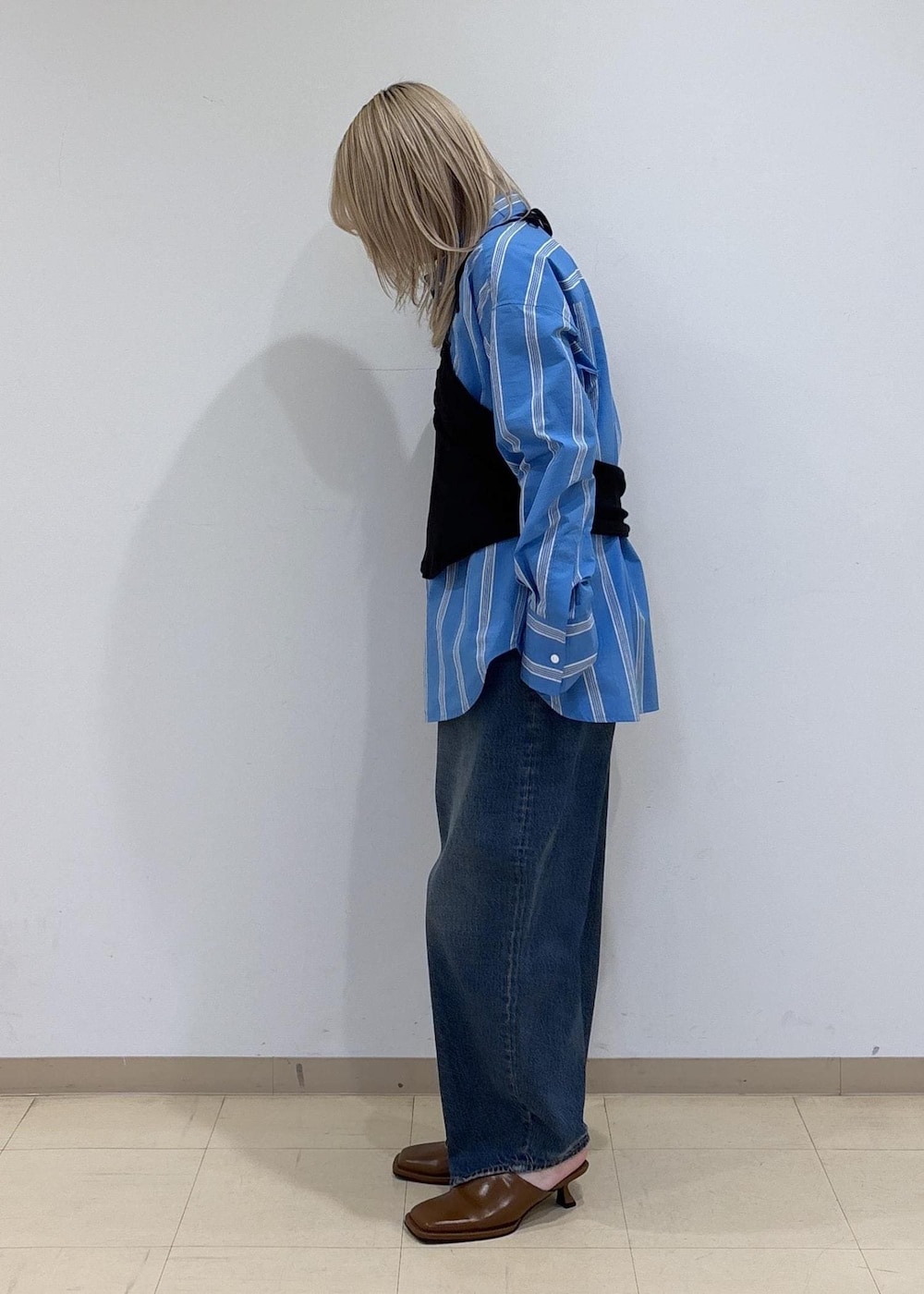 ブラウン系のサンダル、ブルー系のシャツ/ブラウス、ブラック系のTシャツ/カットソーを着用したレディースの春コーディネートの2枚目の写真