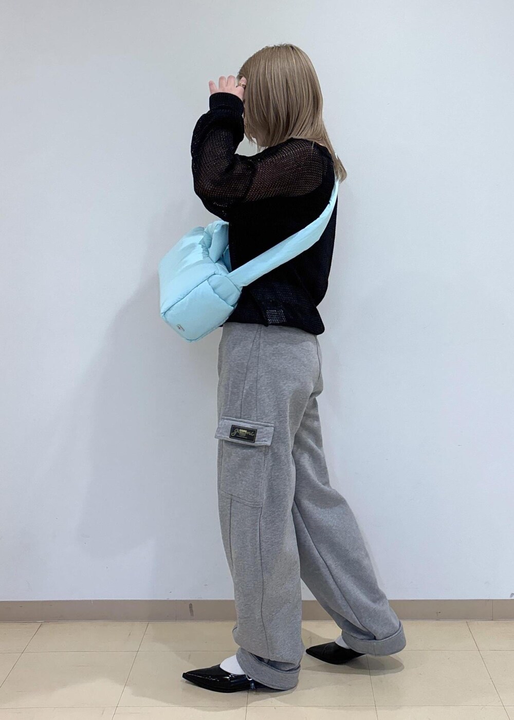 ブラック系のその他シューズ、ブルー系のショルダーバッグ、ブラック系のニット/セーターを着用したレディースの春コーディネートの2枚目の写真