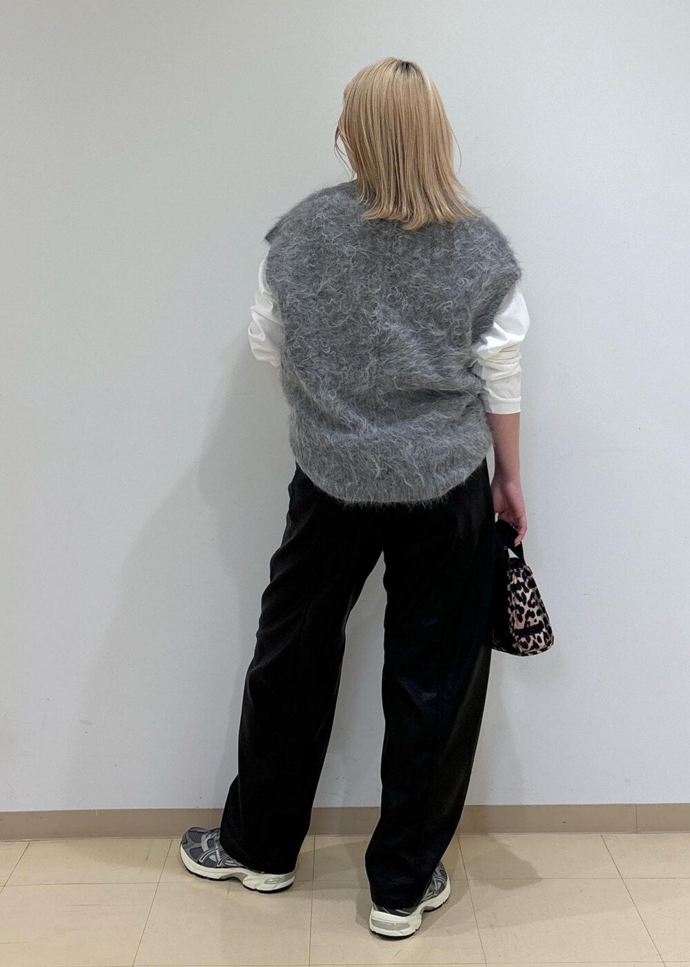 ベージュ系のトートバッグ、ホワイト系のTシャツ/カットソー、グレー系のニット/セーターを着用したレディースの秋コーディネートの3枚目の写真