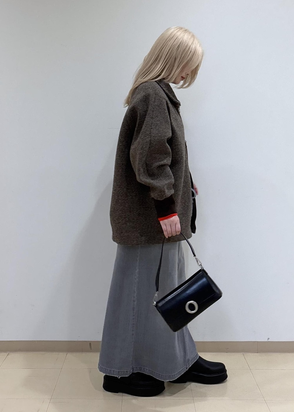 グレー系のデニムスカート、ブラウン系のその他アウター、レッド系のTシャツ/カットソーを着用したレディースの秋コーディネートの4枚目の写真