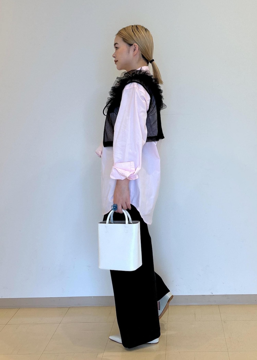 ホワイト系のハンドバッグ、ホワイト系のパンプス、ブラック系のTシャツ/カットソーを着用したレディースの夏コーディネートの2枚目の写真