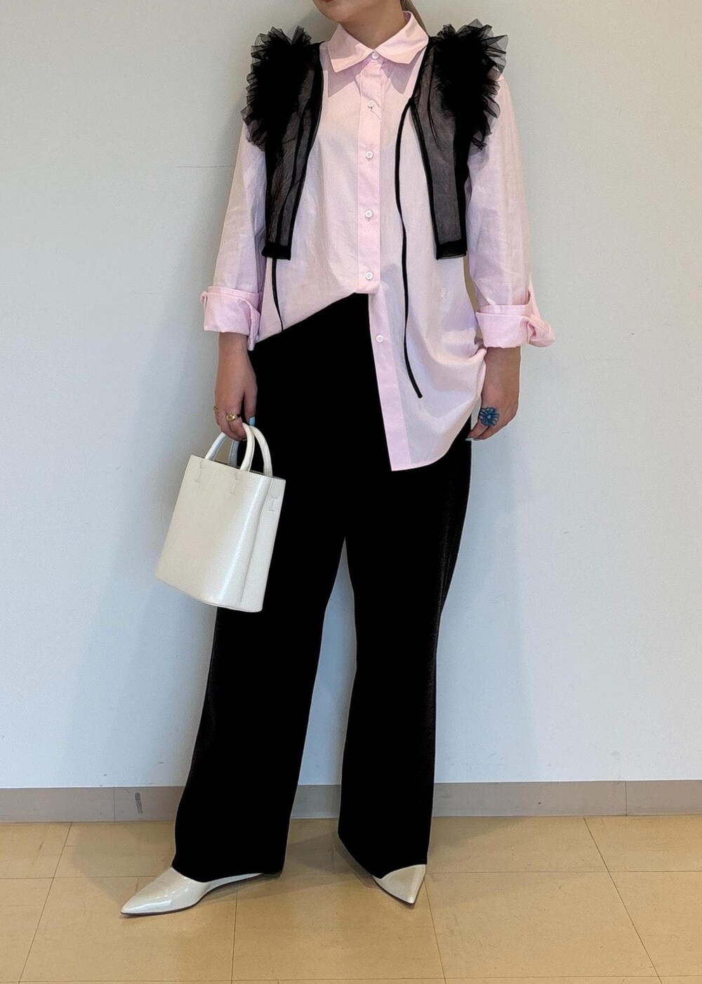 ホワイト系のハンドバッグ、ホワイト系のパンプス、ブラック系のTシャツ/カットソーを着用したレディースの夏コーディネートの6枚目の写真