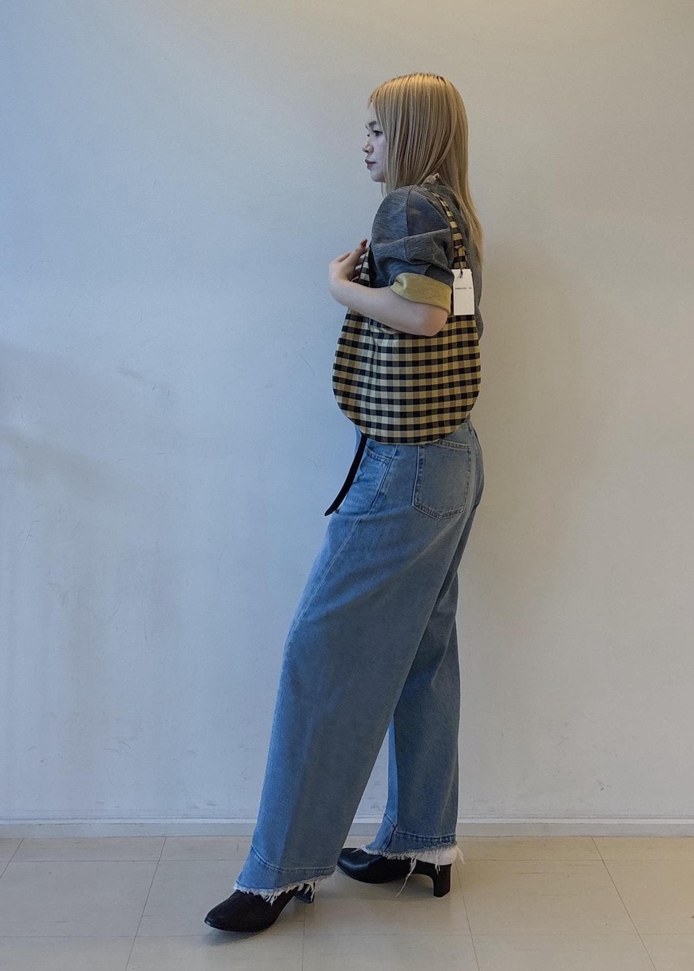ブルー系のデニムパンツ、グレー系のニット/セーター、ブラウン系のサンダルを着用したレディースの夏コーディネートの2枚目の写真