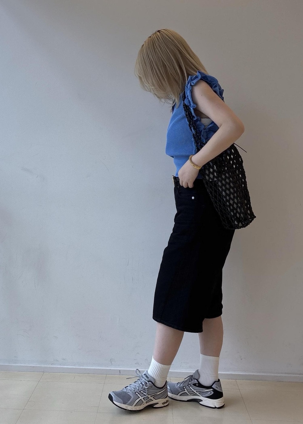 ブラック系のトートバッグ、ブラック系のデニムパンツ、グレー系のスニーカーを着用したレディースの夏コーディネートの2枚目の写真
