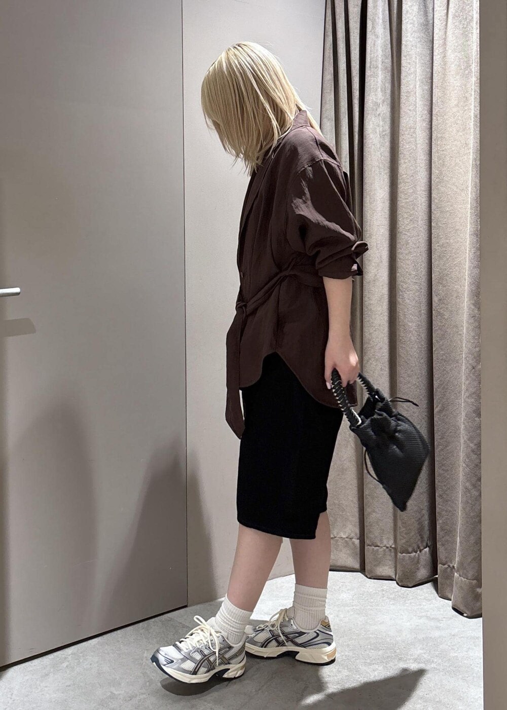 ブラック系のショルダーバッグ、ブラック系のデニムパンツ、ブラウン系のテーラードジャケットを着用したレディースの春コーディネートの2枚目の写真