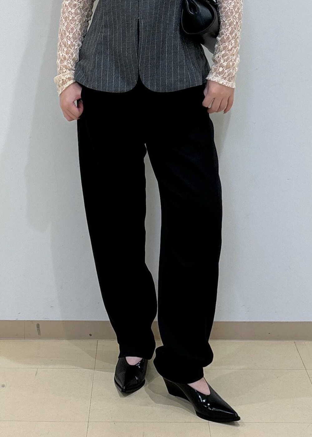 グレー系のキャミソール、ブラック系のその他パンツ、ブラック系のショルダーバッグを着用したレディースの秋コーディネートの6枚目の写真