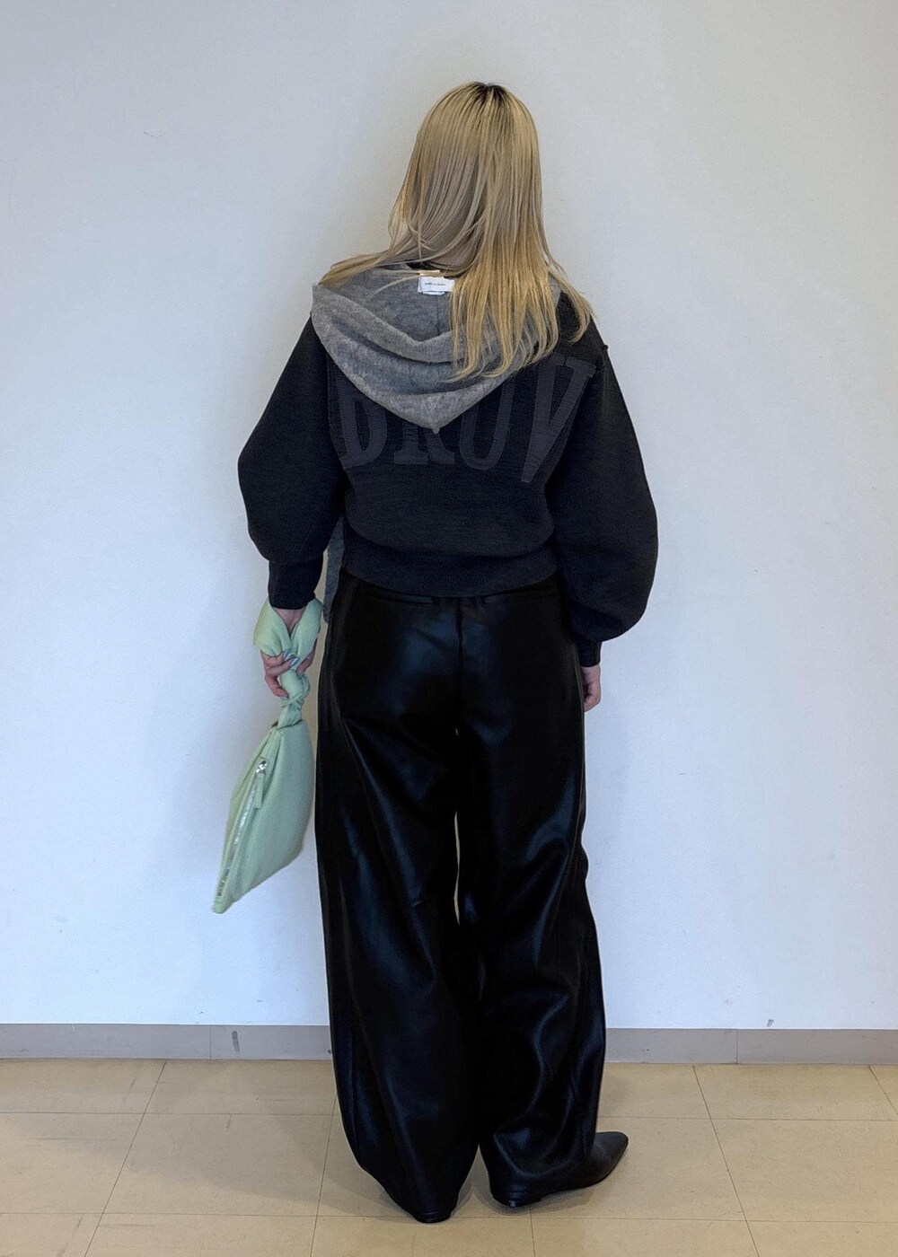 グリーン系のハンドバッグ、ブラック系のパンプス、グレー系のニット/セーターを着用したレディースの秋コーディネートの4枚目の写真