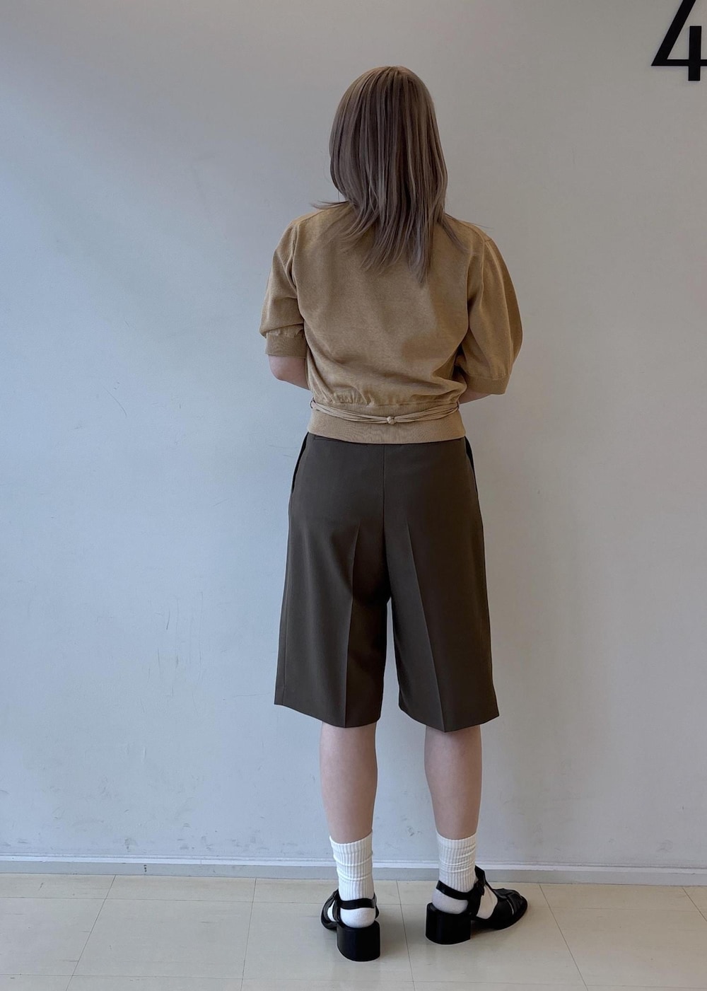 ブラック系のショルダーバッグ、ブラウン系のその他パンツ、ベージュ系のカーディガン/ボレロを着用したレディースの春コーディネートの3枚目の写真