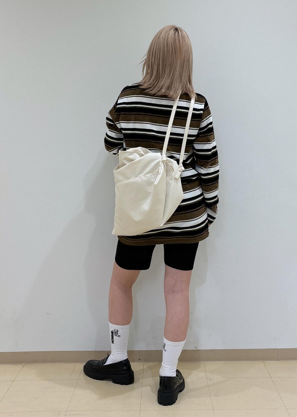 ブラック系のその他パンツ、ブラック系のローファー、ホワイト系のボディバッグ/ウエストポーチを着用したレディースの秋コーディネートの3枚目の写真