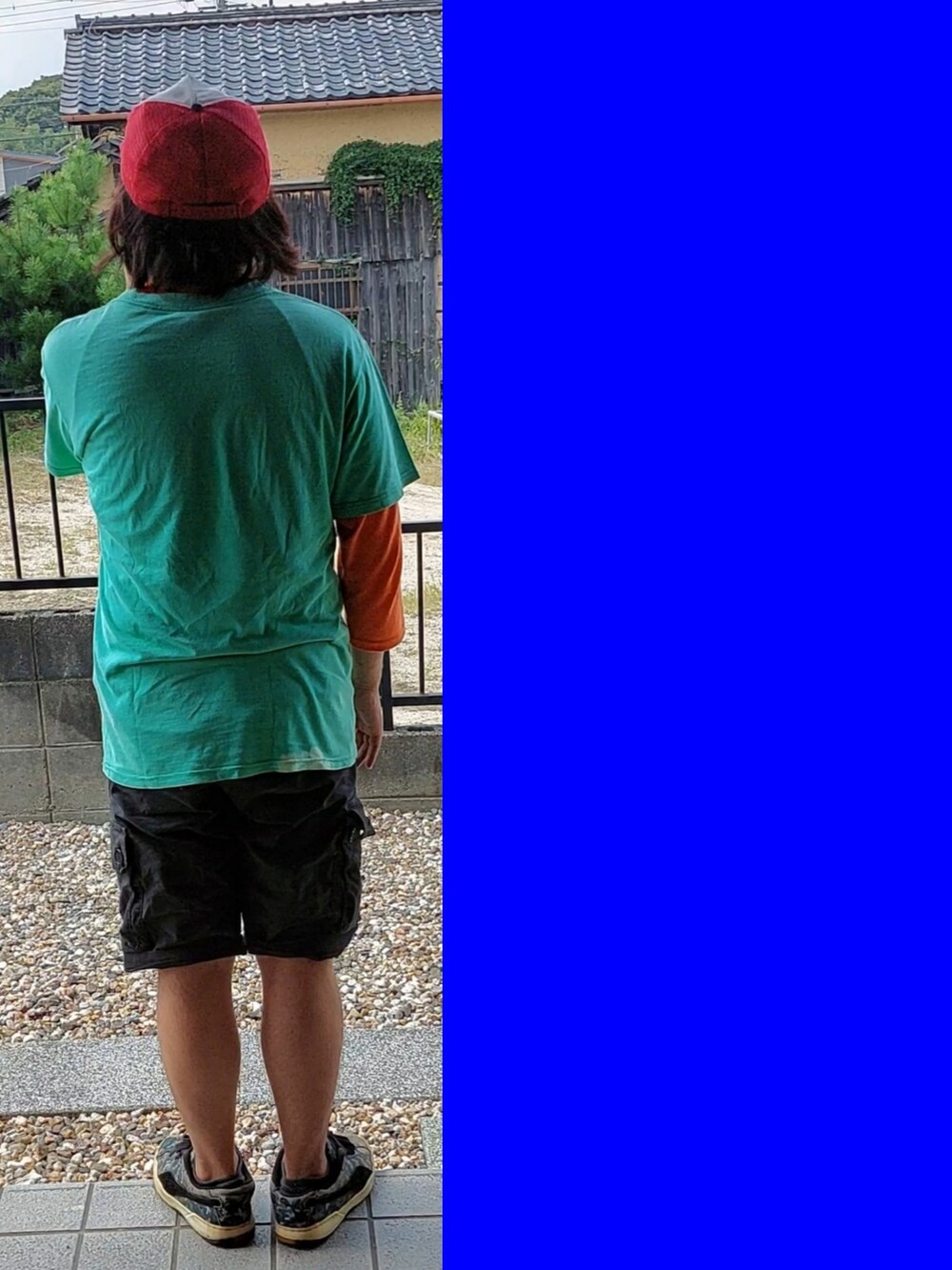 グリーン系のTシャツ/カットソー、オレンジ系のTシャツ/カットソー、ブラック系のカーゴパンツを着用したメンズの秋コーディネートの3枚目の写真