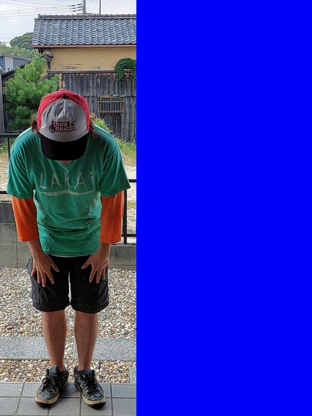 グリーン系のTシャツ/カットソー、オレンジ系のTシャツ/カットソー、ブラック系のカーゴパンツを着用したメンズの秋コーディネートの2枚目の写真