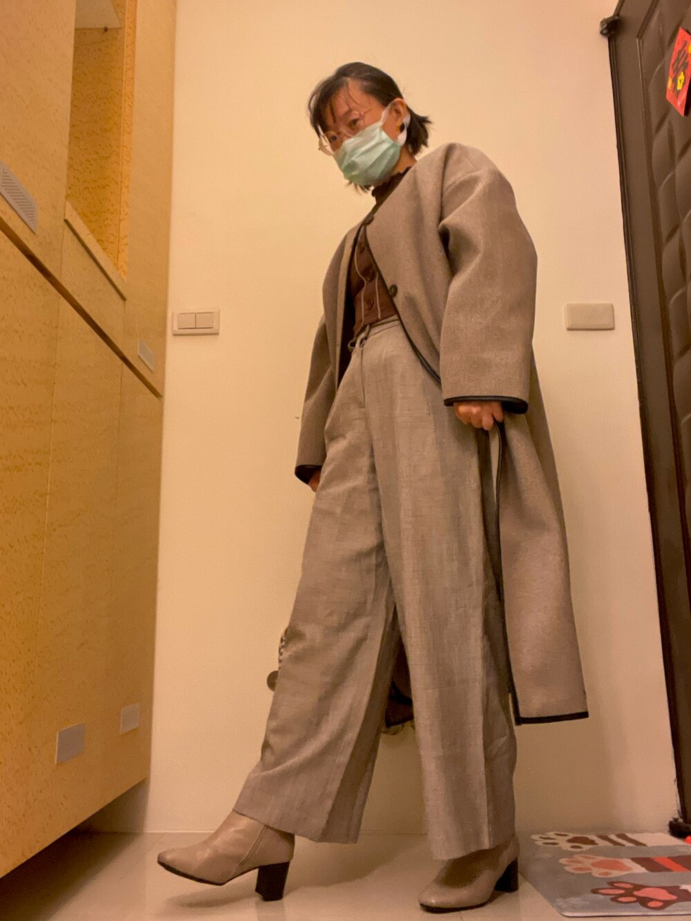 ベージュ系のパンツ、ベージュ系のノーカラーコートを着用したレディースの秋コーディネートの2枚目の写真