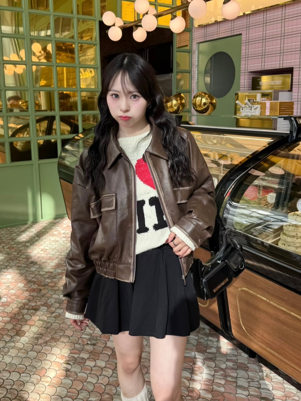 ホワイト系のニット/セーター、ブラウン系のジャケット/アウター、ブラック系のスカートを着用したレディースの夏コーディネートの3枚目の写真