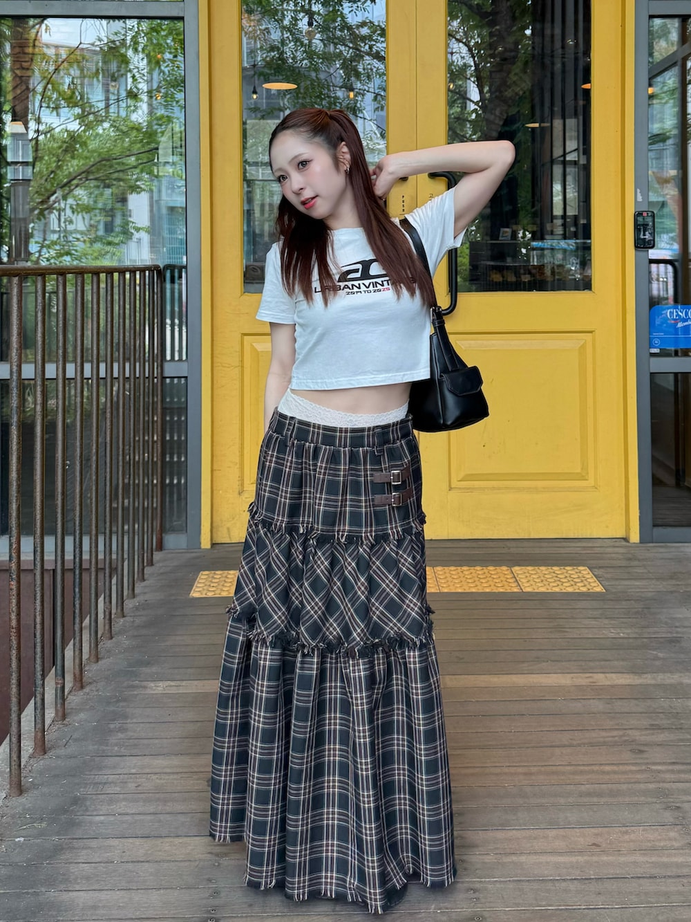 ホワイト系のTシャツ/カットソー、ブラック系のスカート、ブラック系のショルダーバッグを着用したレディースの夏コーディネートの2枚目の写真