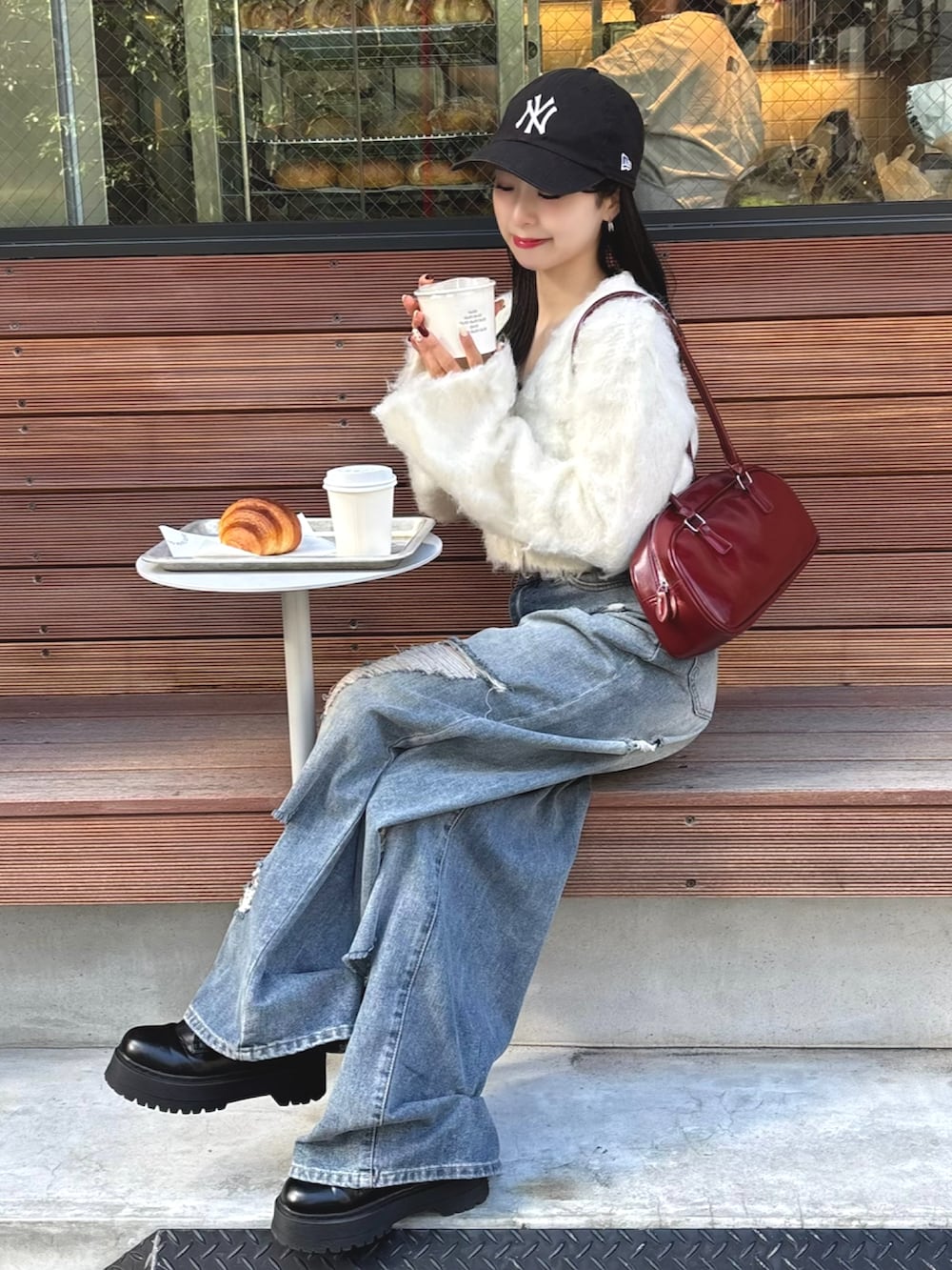 ホワイト系のカーディガン/ボレロ、レッド系のショルダーバッグ、ブルー系のデニムパンツを着用したレディースの秋コーディネートの3枚目の写真