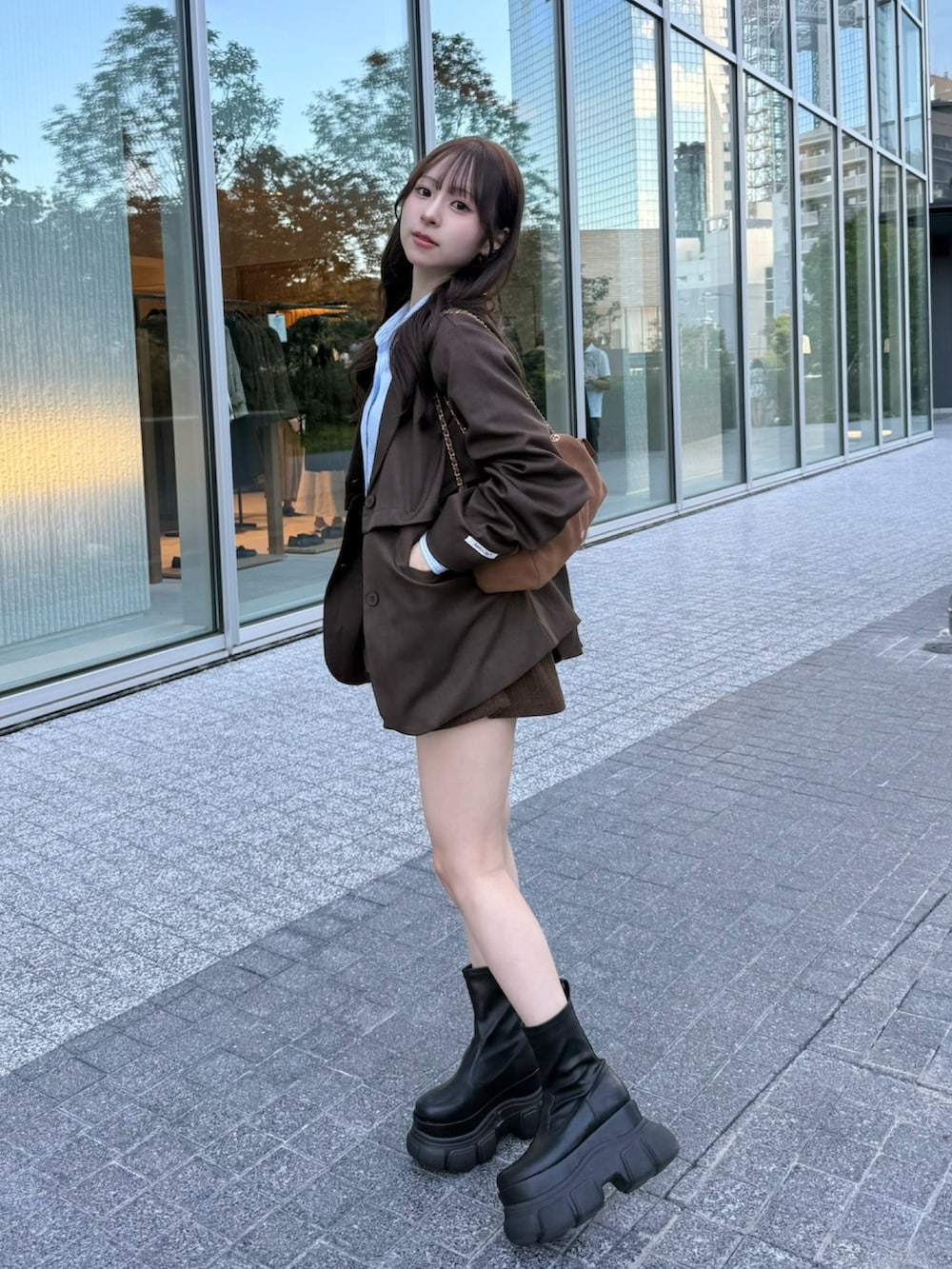 ブルー系のシャツ/ブラウス、ブラウン系のジャケット/アウター、ブラウン系のスカートを着用したレディースの秋コーディネートの2枚目の写真