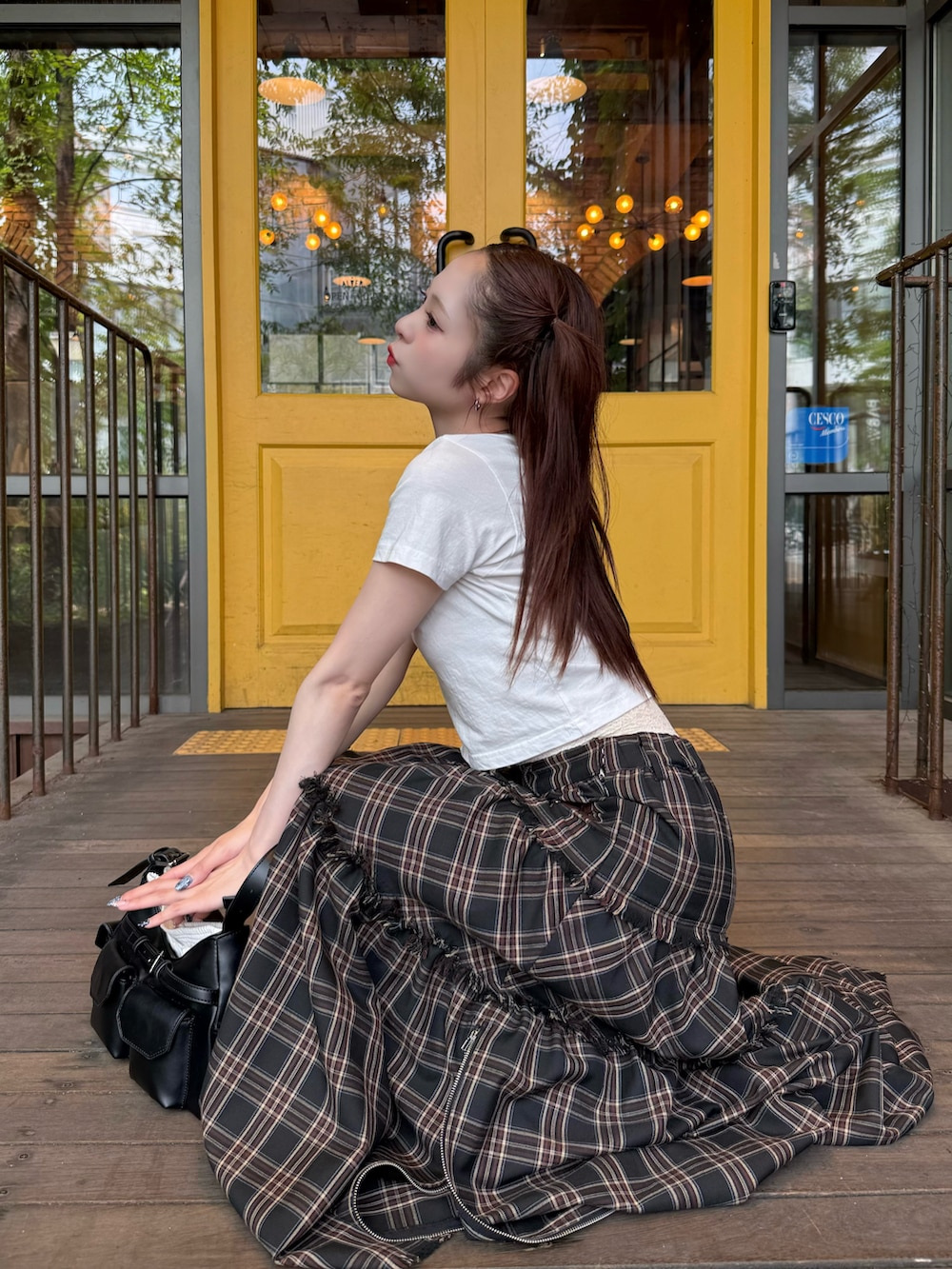 ホワイト系のTシャツ/カットソー、ブラック系のスカート、ブラック系のショルダーバッグを着用したレディースの夏コーディネートの3枚目の写真