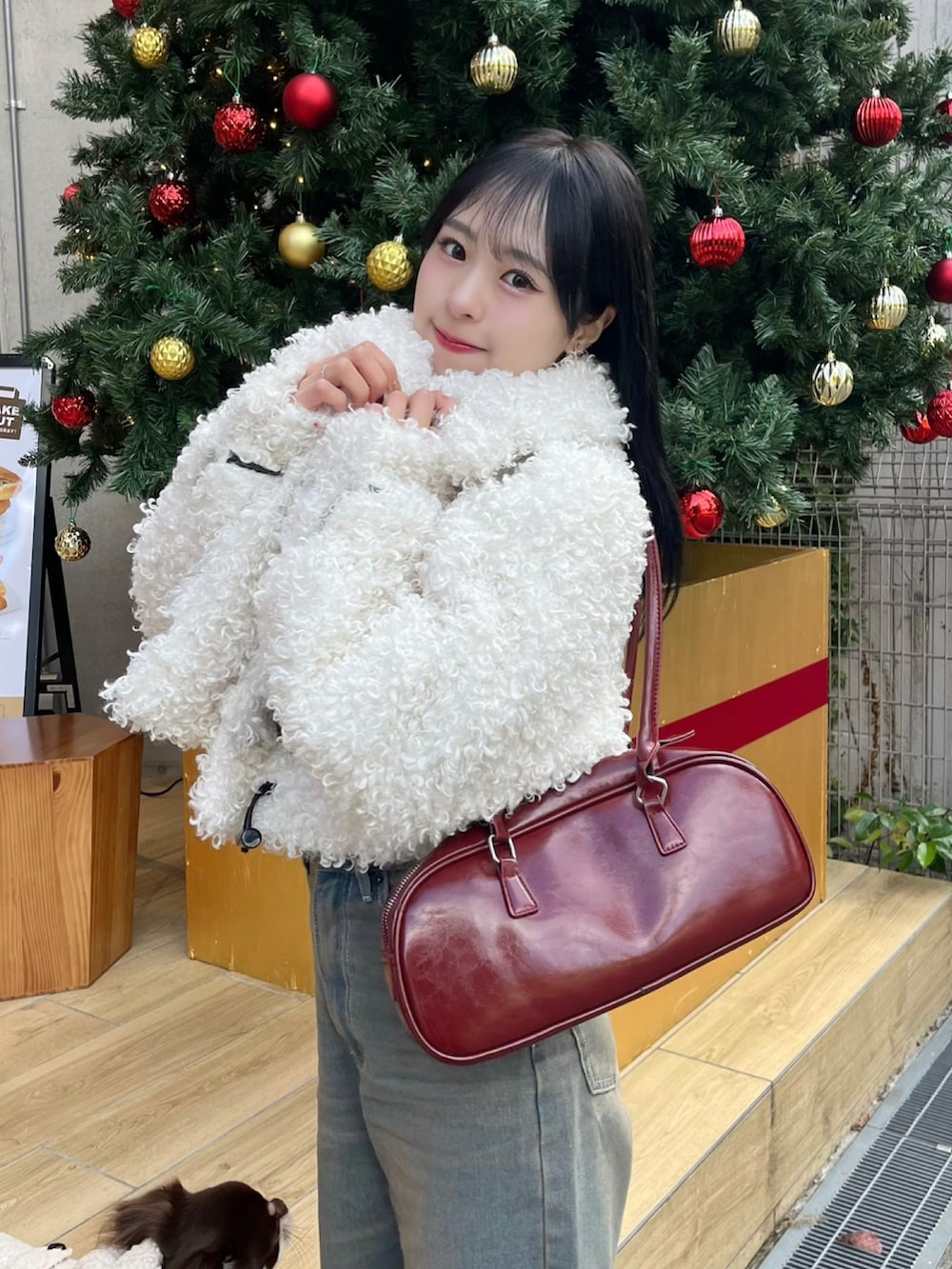 ホワイト系のその他アウター、レッド系のショルダーバッグ、ブルー系のデニムパンツを着用したレディースの秋コーディネートの2枚目の写真