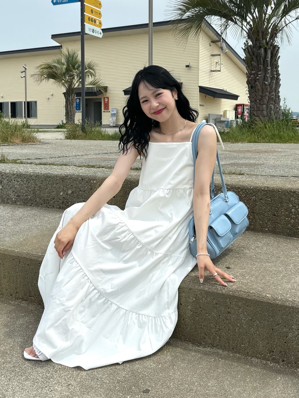 「さらっと晴れやかスナップ、プチプラ、休日スタイル、夏コーデ、ワンピース、キャミワンピ、白ワンピース、デートコーデ、韓国ファッション、ショルダーバッグ、サンダル、お出かけコーデ、ブルー、ホワイトコーデ、ワントーンコーデ」｜「FILLOUのショルダーリボンティアードキャミワンピース（ワンピース、ホワイト系）」を使った、りなてぃさん（骨格ストレート・レディース・150cm）の夏コーディネートの2枚目の写真