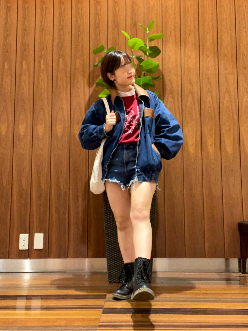 レッド系のスウェット、ブルー系のデニムパンツ、ブラック系のブーツを着用したレディースの秋コーディネートの3枚目の写真