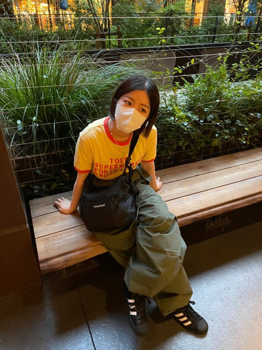 イエロー系のTシャツ/カットソー、ブラック系のスニーカーを着用したレディースの夏コーディネートの2枚目の写真