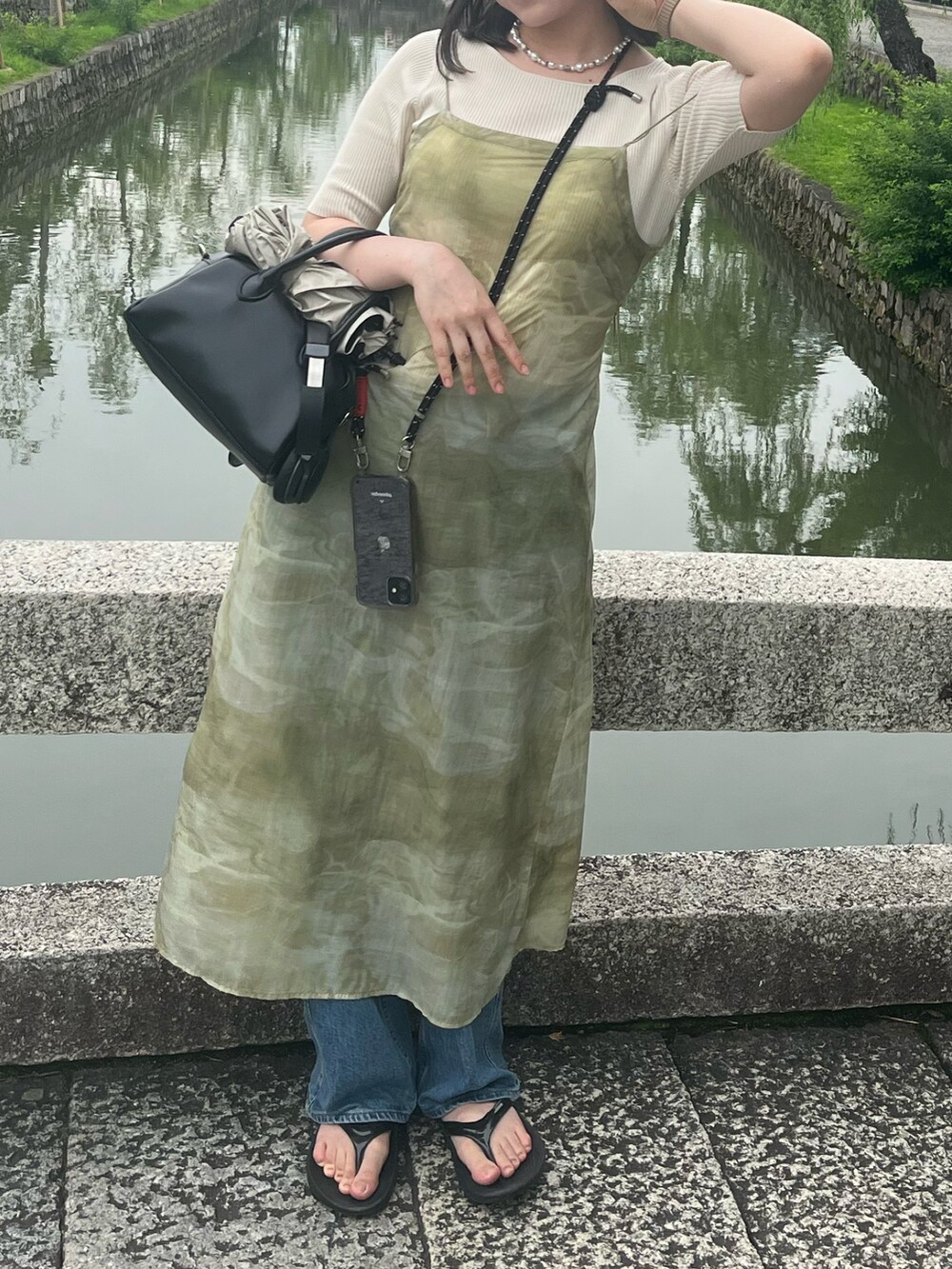 グリーン系のキャミソールを着用したレディースの夏コーディネートの2枚目の写真