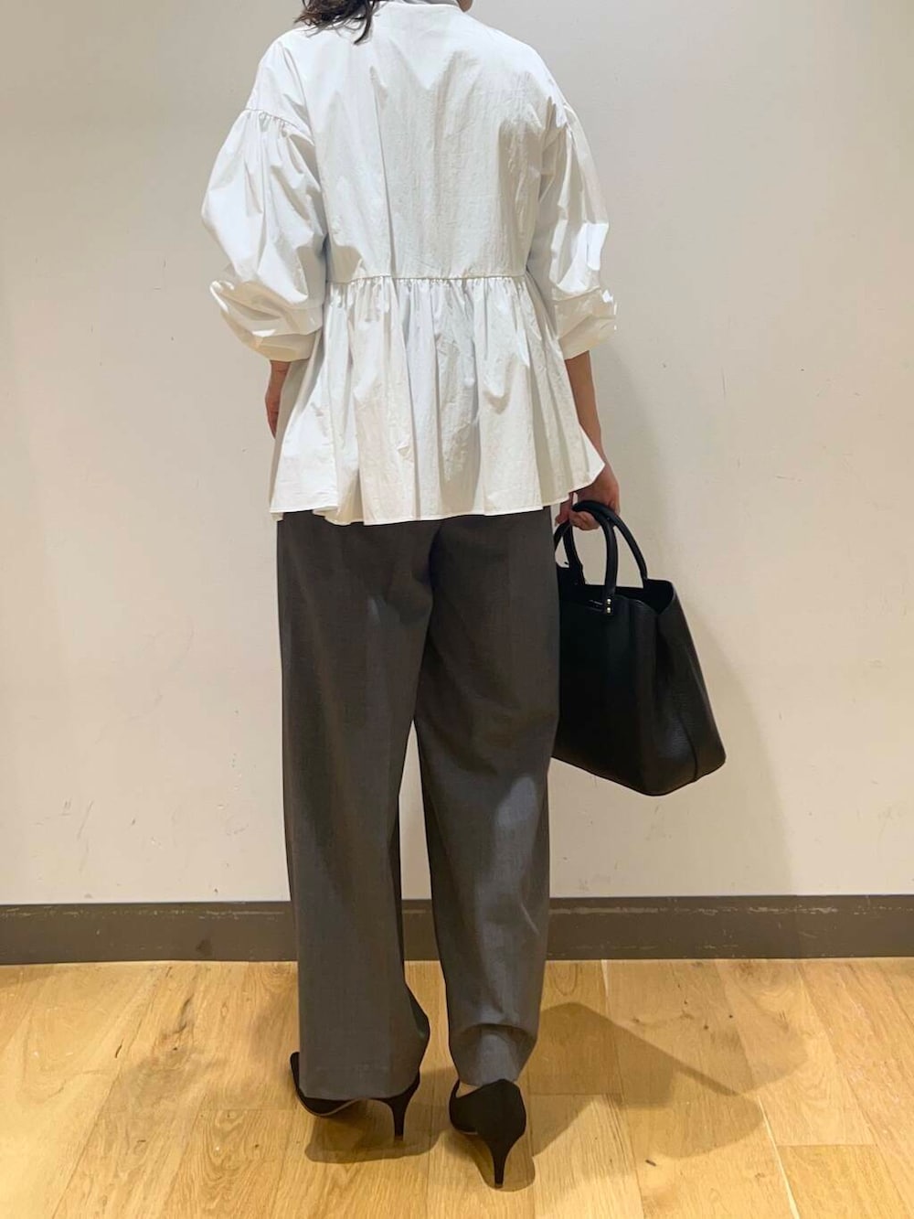 ブラック系のパンプス、ブルー系のTシャツ/カットソー、ホワイト系のシャツ/ブラウスを着用したレディースの秋コーディネートの4枚目の写真