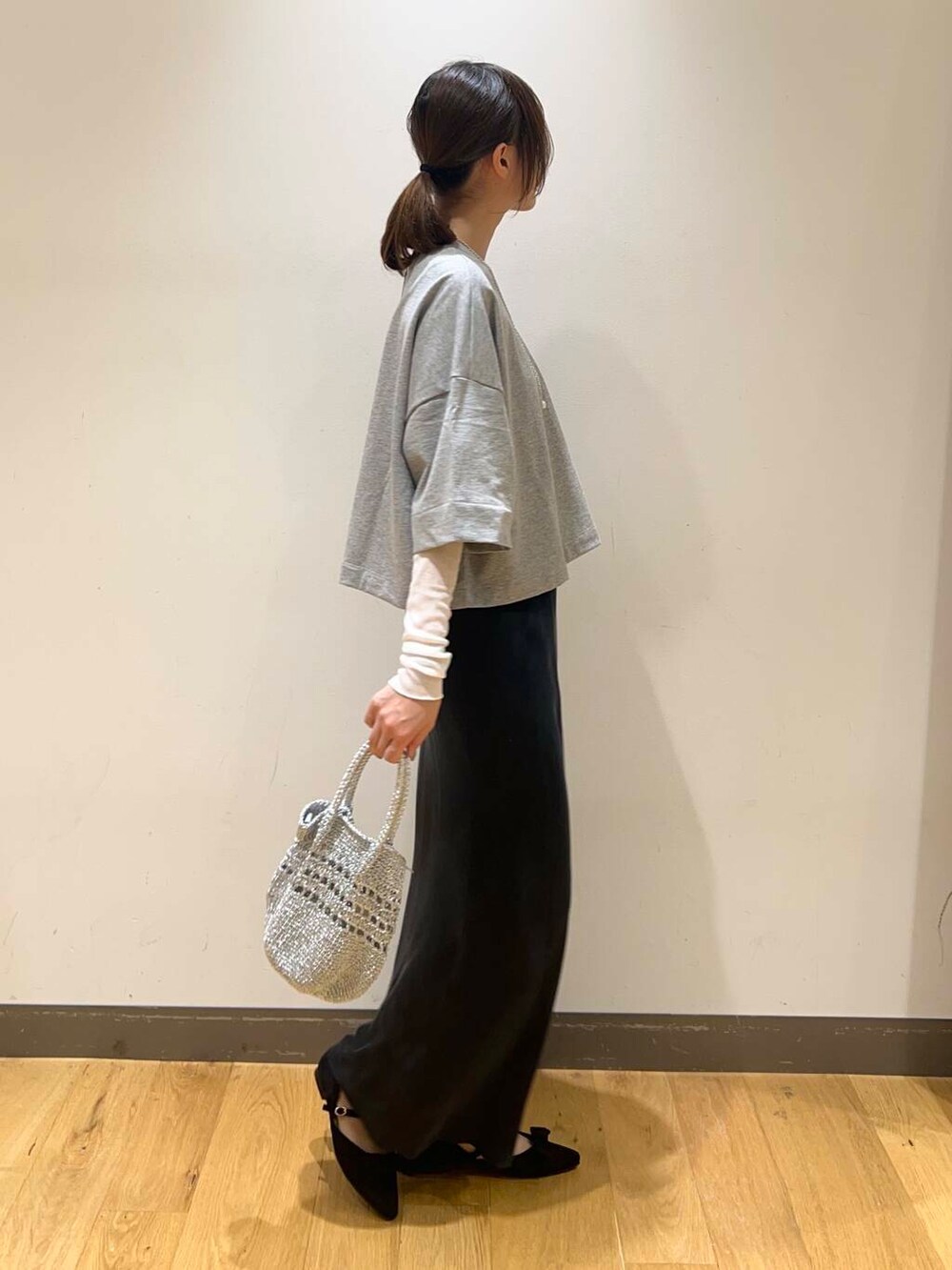 シルバー系のショルダーバッグ、ブルー系のスカート、ホワイト系のTシャツ/カットソーを着用したレディースの春コーディネートの3枚目の写真