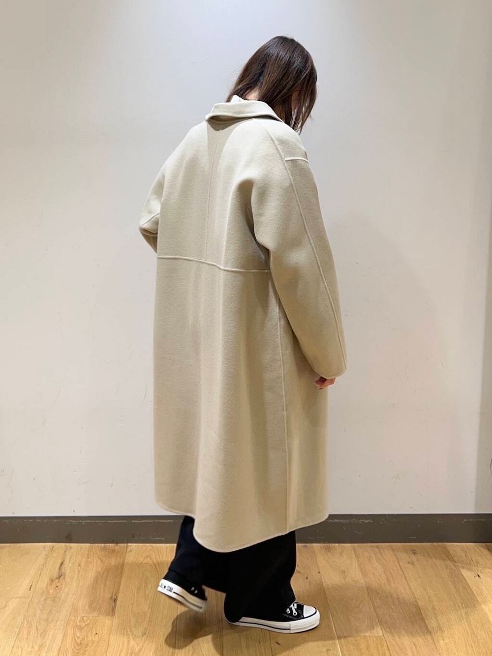 ブラック系のスニーカー、ベージュ系のステンカラーコート、ホワイト系のシャツ/ブラウスを着用したレディースの冬コーディネートの4枚目の写真