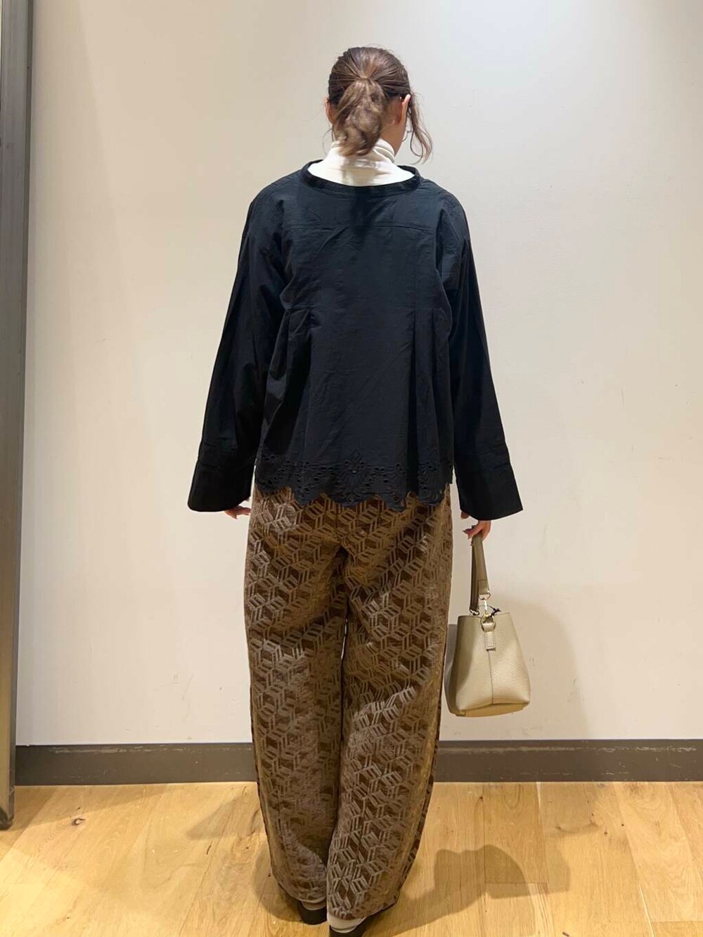 ブラック系のサンダル、ブラック系のカーディガン/ボレロ、ベージュ系のショルダーバッグを着用したレディースの秋コーディネートの3枚目の写真