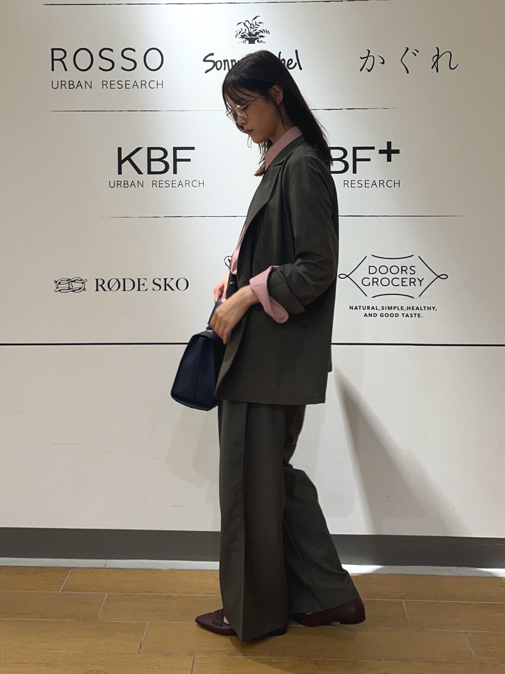 ピンク系のシャツ/ブラウス、ブラウン系のその他アウター、ブルー系のハンドバッグを着用したレディースの秋コーディネートの3枚目の写真