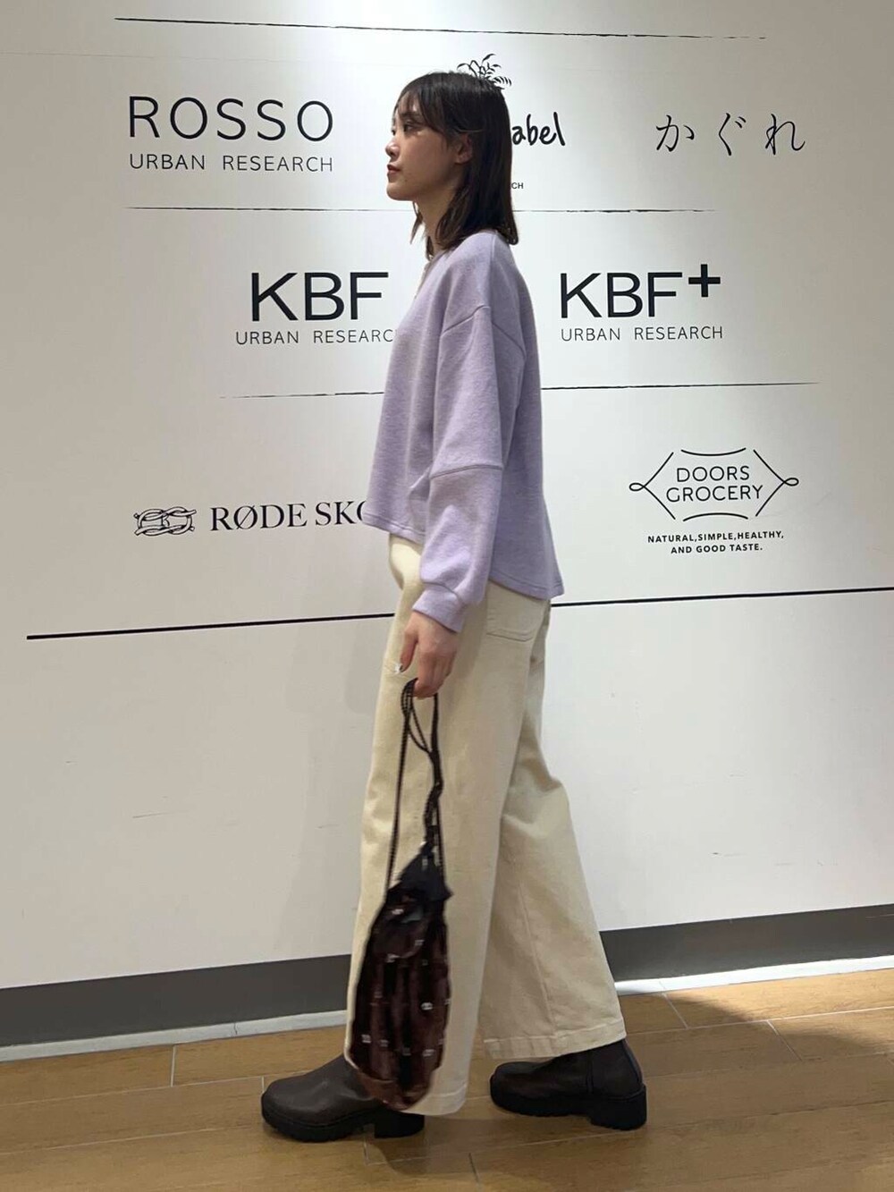 ブラウン系のブーツ、ブラウン系のショルダーバッグ、パープル系のTシャツ/カットソーを着用したレディースの冬コーディネートの3枚目の写真