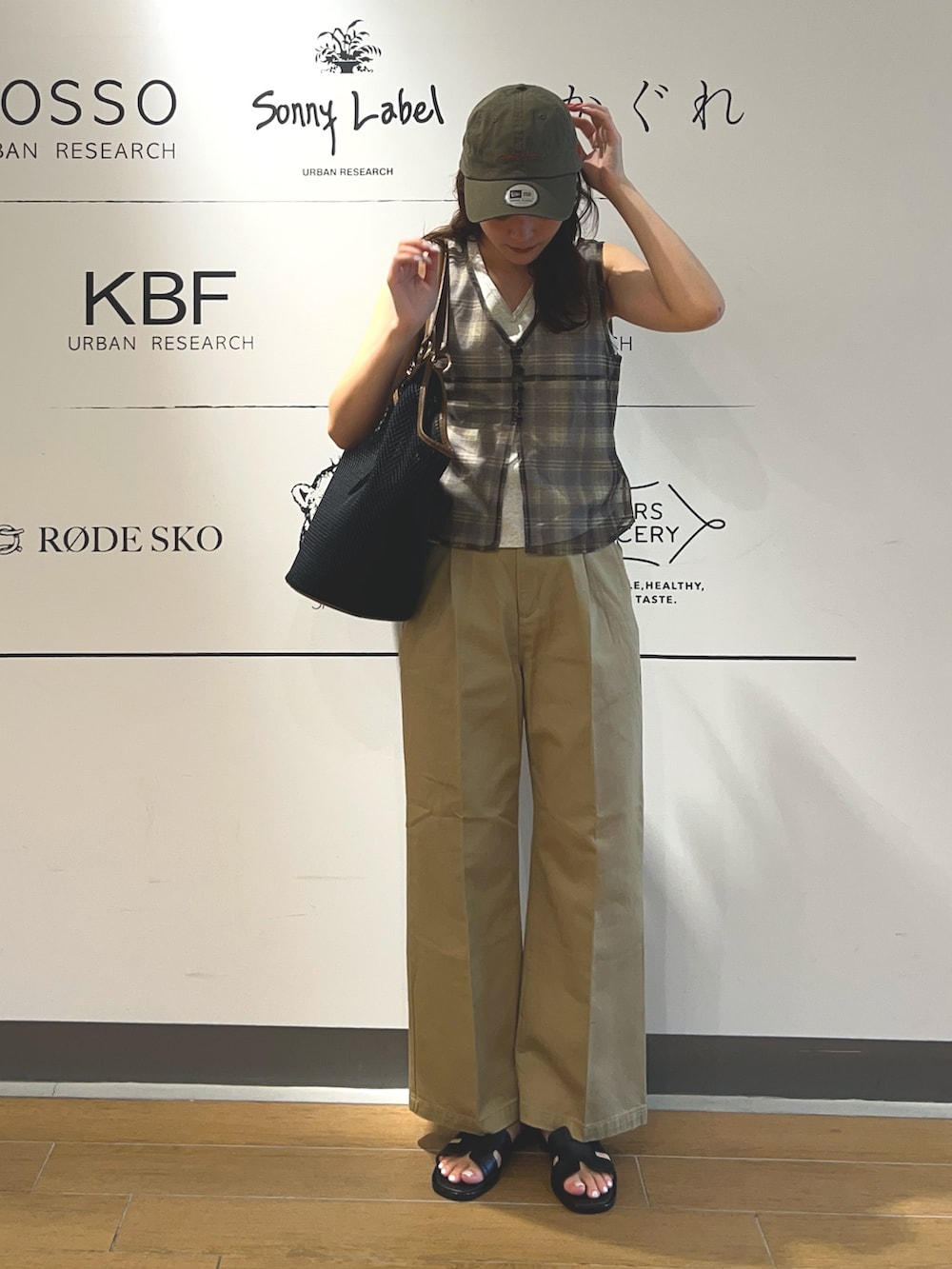 ベージュ系のその他パンツ、ブラック系のトートバッグ、ブラウン系のキャップを着用したレディースの夏コーディネートの2枚目の写真