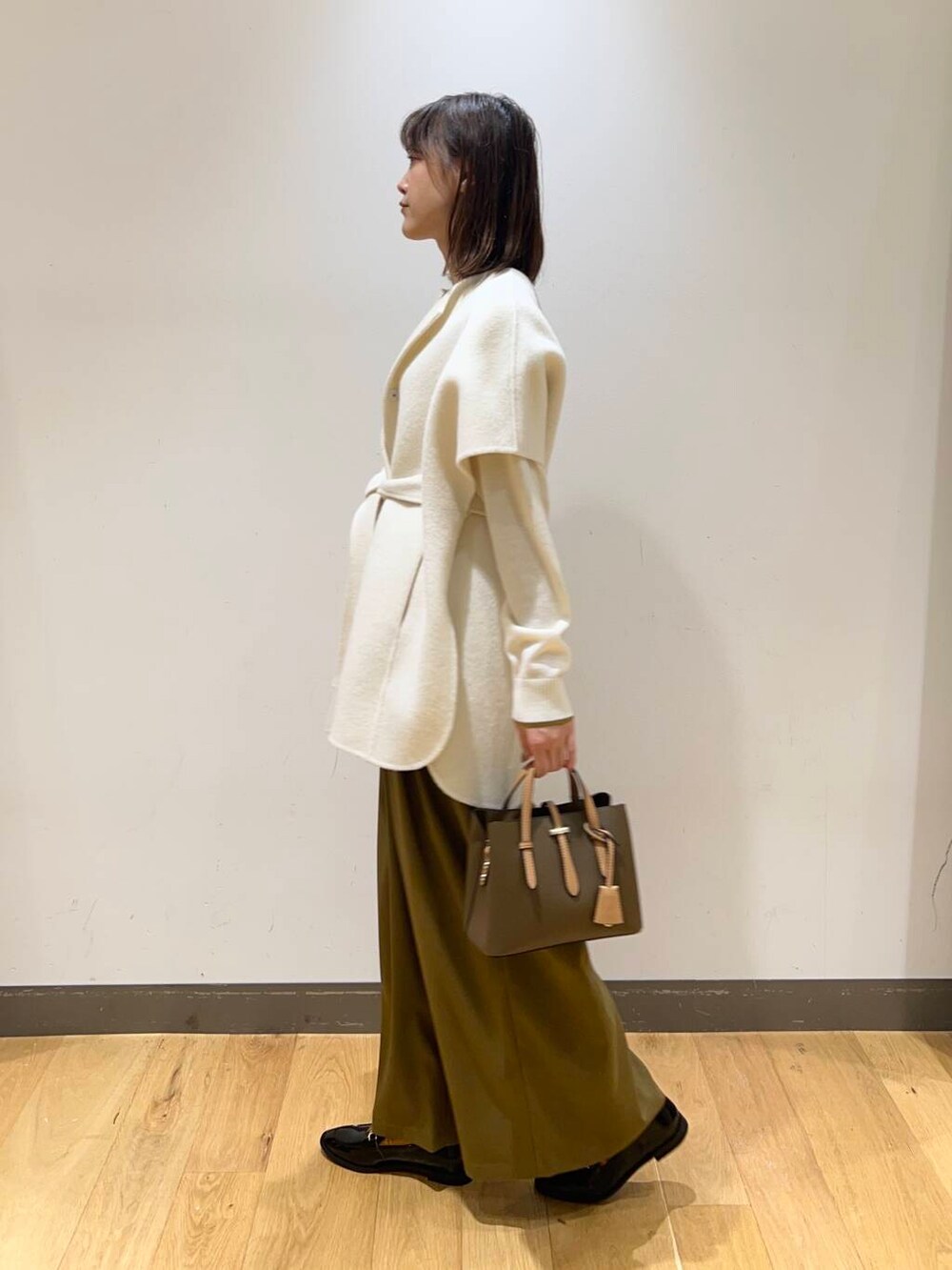 ブラック系のローファー、ブラウン系のハンドバッグ、ベージュ系のその他パンツを着用したレディースの冬コーディネートの3枚目の写真