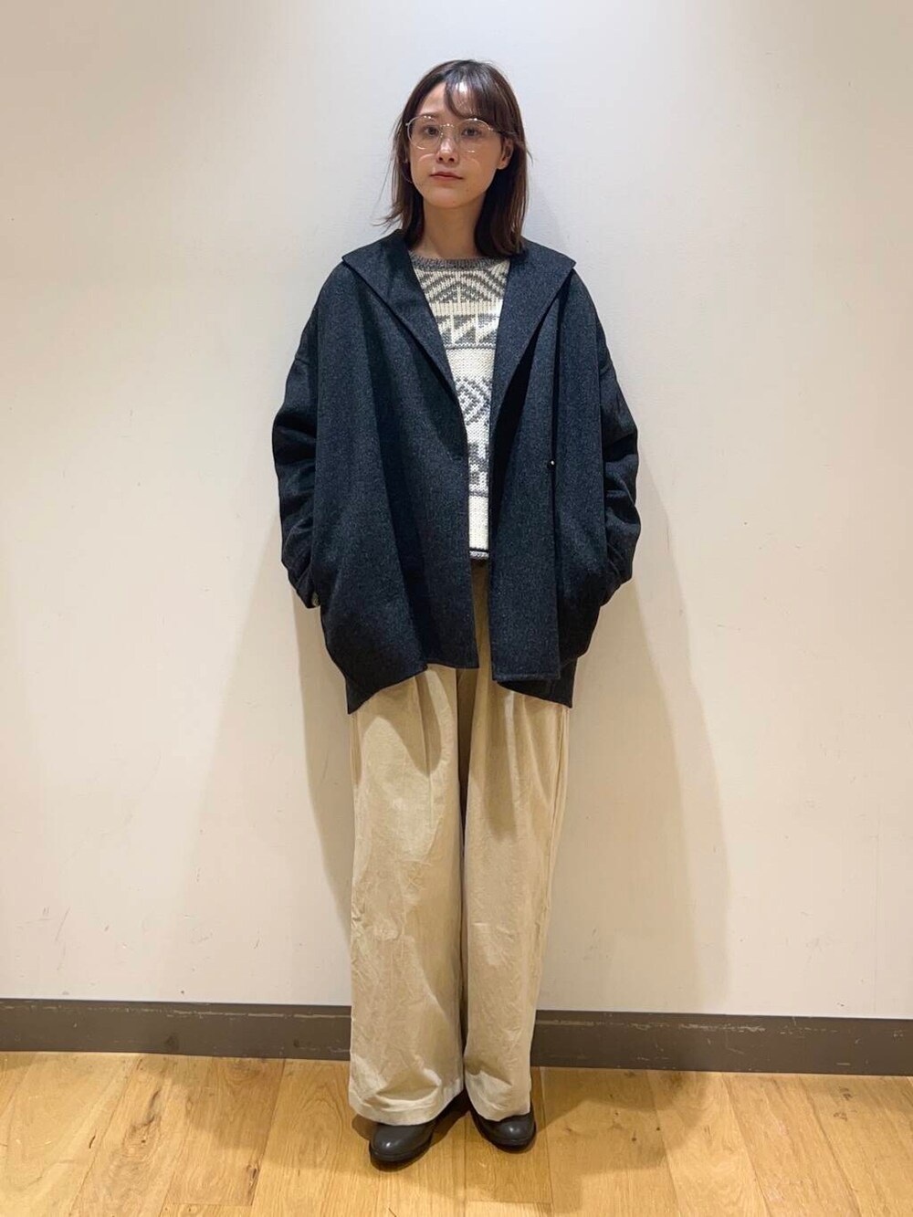 グレー系のその他アウター、グレー系のブーツ、ホワイト系のニット/セーターを着用したレディースの冬コーディネートの2枚目の写真