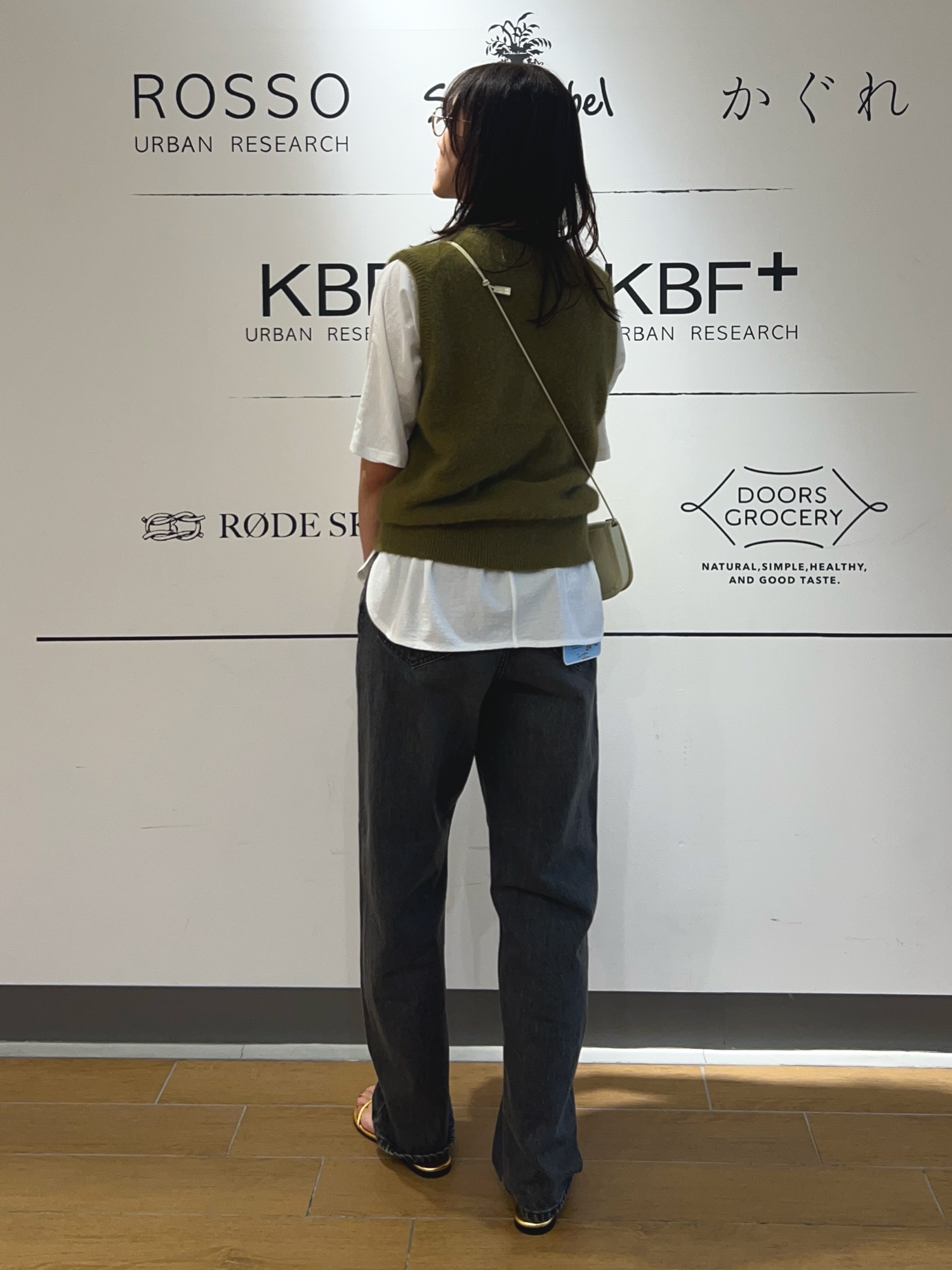 グリーン系のベスト、ホワイト系のTシャツ/カットソー、ホワイト系のショルダーバッグを着用したレディースの夏コーディネートの3枚目の写真