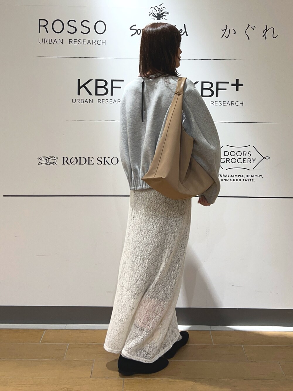 グレー系のスウェット、ホワイト系のスカート、ベージュ系のトートバッグを着用したレディースの冬コーディネートの4枚目の写真