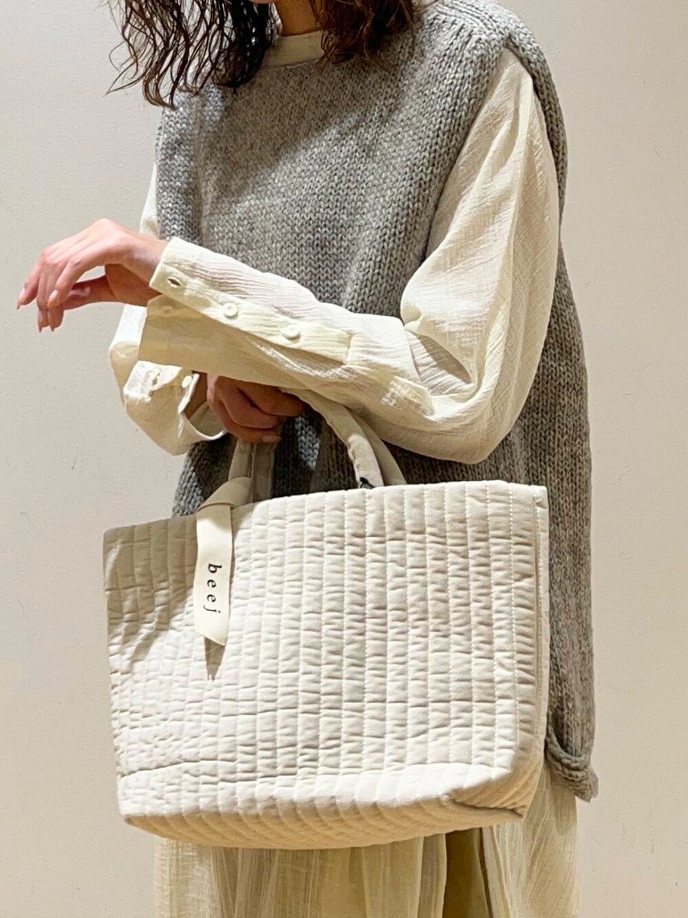 グレー系のニット/セーター、ホワイト系のトートバッグ、ブラック系のその他シューズを着用したレディースの秋コーディネートの3枚目の写真